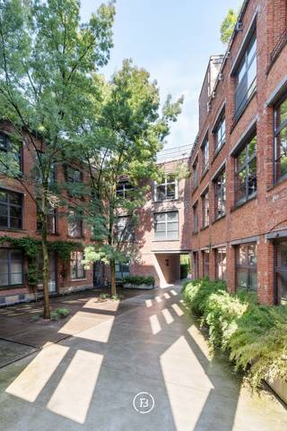 In de iconische voormalige Victoria koekjesfabriek in Koekelberg, uitzonderlijke loft van 408 m² (EPC) met indrukwekkende volumes en hoge plafonds.<br /><br />Gelegen op het gelijkvloers en bestaande uit een royale inkomhal met vestiaire en gastentoilet, semi-industriële keuken, spectaculaire leefruimte van 100 m² met eethoek, slaapkamer met badkamer en een tweede kamer, ideaal als bureau of extra slaapkamer.<br /><br />Op de onderliggende verdieping bevindt zich een prachtige slaapkamer van 45 m² met aansluitende badkamer met bad en stoomdouche, evenals een zeer ruime kelder.<br /><br />Het project beschikt over uitstekende gemeenschappelijke faciliteiten, waaronder een uitgeruste fitnessruimte en een verwarmd binnenzwembad.<br /><br />Een unieke combinatie van industrieel erfgoed, hedendaags comfort en uitzonderlijke leefruimtes.<br /><br />Mogelijkheid tot aankoop van een ruime staanplaats voor twee wagens voor €65.000.