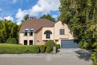 Op een strategische locatie in Schiplaken, met een vlotte verbinding naar Brussel, Leuven en Antwerpen, vinden we deze karaktervolle villa waar ruimte, licht en privacy harmonieus samenkomen. De woning biedt ca. 377 m² bewoonbare oppervlakte op een prachtig perceel van 11a 25ca.<br /><br />Bij binnenkomst valt meteen de openheid van de woning op. Hoge plafonds, maatwerk en royale raampartijen creëren een aangenaam gevoel van ruimte en licht. De leefruimtes staan in directe verbinding met de tuin. De keuken geniet dankzij de grote glaspartijen van een overvloed aan natuurlijk licht, terwijl het ruime schuifraam in de leefruimte een vanzelfsprekende overgang maakt tussen binnen en buiten. De gelijkvloers wordt nog vervolledigd met een technische ruimte en dubbele inpandige garage.<br /><br />De aangelegde tuin vormt een oase van rust, met als blikvanger de sfeervolle koivijver. Het automatische zonnescherm maakt het mogelijk om ook op zonnige dagen optimaal van deze buitenruimte te genieten.<br /><br />Op de eerste verdieping bevinden zich drie slaapkamers, waaronder de master bedroom met ensuite badkamer en geïntegreerde sauna. De tweede verdieping is volledig ingericht als extra slaapkamer en beschikt bovendien over praktische bergruimte.<br /><br />Een villa met karakter, royale leefruimtes en een sterke connectie met de tuin, op een locatie waar bereikbaarheid en rust elkaar ontmoeten.