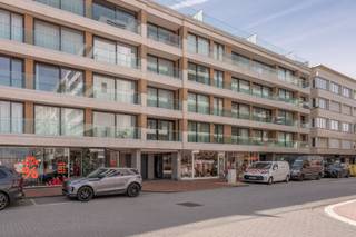 Dit appartement op de 4e verdieping bevindt zich op een strategische centrumlocatie nabij de Lippenslaan en de Kustlaan. De winkels liggen voor de deur en het strand bevindt zich op korte wandelafstand. Het interieur werd volledig vernieuwd, waarbij gekozen is voor een eigentijdse stijl die afwijkt van de standaard renovatie. Bovendien is het volledige appartement uitgerust met vloerverwarming, wat zorgt voor een aangenaam en constant leefcomfort.<br /><br />Bij binnenkomst valt meteen de lichtinval in de woonkamer op. De open keuken staat in direct contact met de leefruimte en is voorzien van een royaal werkblad in natuursteen. Dit materiaal keert ook terug in de badkamers, wat zorgt voor een mooie samenhang doorheen de woning. Aan de keuken is een vaste zitbank geïntegreerd. Vanaf deze plek kijkt u zijdelings uit richting het Lichttorenplein en de zee.<br /><br />Het plan telt drie slaapkamers. De twee ruime slaapkamers beschikken elk over een eigen badkamer en op maat gemaakte dressingkasten die zorgen voor rust en esthetiek. Beide vertrekken geven rechtstreeks toegang tot het grote zonneterras aan de achterzijde. De derde kamer is slim benut als slaaphoek met een ingebouwd stapelbed. Een wand in gekleurd glas brengt hier daglicht binnen zonder in te boeten op privacy.<br /><br />Dit eigendom op Kustlaan 16 combineert een doordachte architectuur met een sterke centrumlocatie. Het is daarmee de ideale kans voor wie op zoek is naar een waardevolle vastgoedinvestering of een comfortabel tweede verblijf aan de kust.<br /><br />Een bezoek inplannen kan via 0472 26 65 17 of info@immonano.be.