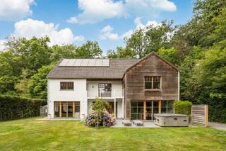 <p>In een bijzonder groene en residentiële omgeving in Schilde bevindt zich deze statige Long Island villa. Dankzij de royale volumes, de doordachte indeling en de vele slaapkamers is deze woning ideaal voor grote gezinnen.</p>
<p><strong>GELIJKVLOERS<br /></strong>Via de indrukwekkende <strong>inkomhal van 35m²</strong> met vestiairekasten, gastentoilet en handenwasser betreedt u de woning.<br />Aansluitend bevindt zich een <strong>bureel van 15m²</strong> op parket, ideaal als home office.<br />De ruime <strong>woonkamer van 37m²</strong> op parket sluit aan op de <strong>eetkamer van 29m²</strong>.<br />Verder beschikt de woning over een gezellige <strong>tv-kamer van 22m².<br /></strong>Het hart van de woning is de <strong>leefkeuken van 50m²</strong>, uitgerust met een kookeiland, keramische kookplaat, vaatwasser, heteluchtoven, dubbele spoelbak, composieten werkblad, ontbijthoek en eveneens een aansluiting voor een gashaard.<br />Naast de keuken bevindt zich een praktische <strong>berging of bijkeuken van 8m²</strong> met ingemaakte kasten.</p>
<p>De fraai aangelegde tuin biedt alle privacy en is bereikbaar via een automatische toegangspoort.</p>
<p>Verder beschikt het perceel over een <strong>terras van 65 m² </strong>op tegel<strong>,</strong> een tuinhuis van 10 m² en een fietsenstalling.</p>
<p><strong>1STE VERDIEPING<br /></strong>Op de eerste verdieping geeft de ruime overloop toegang tot vijf volwaardige slaapkamers.<br /><strong>De hoofdslaapkamer van 26 m² </strong>beschikt over een eigen terras en sluit aan op een luxueuze <strong>badkamer van 22 m²,</strong> ingericht met een ligbad, inloopdouche, dubbel lavabomeubel, toilet en sauna.<br /><strong>2<sup>de</sup> slaapkamer</strong> <strong>van 19 m²</strong> beschikt over een <strong>aparte dressing</strong>.<br /><strong>2<sup>de</sup> badkamer </strong>met inloopdouche en dubbel lavabomeubel.<br /><strong>3<sup>de</sup> slaapkamer</strong> <strong>van 23 m²</strong> heeft eveneens toegang tot een terras.<br /><strong>3<sup>de</sup> badkamer</strong> met inloopdouche en lavabomeubel.<br /><strong>4<sup>de</sup> slaapkamer</strong> <strong>van 20 m²</strong> is voorzien van ingemaakte kasten en geeft eveneens uit op het terras.<br /><strong>5<sup>de</sup> slaapkamer 17 m².</strong></p>
<p>Op deze verdieping bevindt zich bovendien een praktische <strong>wasplaats van 11 m²</strong> met uitgietbak en aansluitingen voor wasmachine en droogkast.</p>
<p><strong>2DE VERDIEPING<br /></strong>Deze verdieping van 117m² biedt tal van mogelijkheden om bijkomende slaapkamers, hobbyruimte of een polyvalente ruimte te creëren.</p>
<p><strong>BIJZONDERHEDEN<br /></strong>De vermelde “bewoonbare oppervlakte” is gebaseerd op de “bruikbare vloeroppervlakte” zoals vermeld in het EPC.<br />14 Zonnepanelen, kruipruimte, front porch hardhout, regenwaterput, verwarming op aardgas, beneden vloerverwarming, boven radiators, dubbele beglazing, houten schrijnwerk, vaste vliegenhorren, alarmsysteem en videofoon.</p>
<p><strong>POSITIEVE PUNTEN<br /></strong>Asbestvrij<br />Hoge plafonds<br />14 zonnepanelen<br />Gunstige EPC-score<br />Veel parkeergelegenheid<br />7 slaapkamers & 3 badkamers<br />Groene, residentiele omgeving</p>