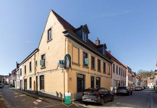 Een zorgvuldig en kwalitatief gerestaureerde ruime hoekwoning met 4 slaapkamers en een garage voor 2 auto's op een rustige en uiterst centrale ligging.<br /><br />Dit ruime breedhuis dateert vermoedelijk uit de 19de eeuw, met kern uit de 17de eeuw en werd in 2017 compleet "gestript" en met kwalitatieve en natuurlijke materialen zorgvuldig heropgebouwd. Vloeren zijn in natuursteen en massief parket, keukenwerkblad uit natuursteen, allemaal draai-kiepramen, veel lichtinval,...<br />Op het gelijkvloers kom je binnen in een ruime hal met gastentoilet en toegang tot het mooie bureel, met mooie authentieke lambrisering. Vervolgens ga je via de ingemaakte vestiairekasten naar de volledig geïnstalleerde keuken met exclusief AGA-fornuis. De eetplaats geeft uit op het gedeeltelijk overdekte binnenterras, waar je ook van in het gezellige, verhoogde salon op uitkomt. <br /><br />Aansluitend aan de keuken kan je naar de garage van bijna 45m². Er kunnen 2 wagens in en daarnaast is er nog plaats voor wasruimte en berging. In de garage is uitgerust met een grote elektrische poort en ook een gevelbrede pivoterende deur naar het terras. Een terras waarop het - mooi ingesloten en zonder inkijk - het hele jaar door gezellig toeven is.<br /><br />Op de eerste verdieping bevinden zich de riante master bedroom met maatkasten, een royale badkamer met douche, ligbad, afgescheiden toilet en een dubbele lavabo en tenslotte nog een slaapkamer.<br /><br />Op de tweede verdieping hebben we nog slaapkamers 3 en 4 onder het prachtige dakgebinte.<br />Onder het huis vind je nog een gerieflijke kelder.<br /><br />Een exclusief afgewerkte woning met historiek, charme, een dubbele garage en 4 slaapkamers op 160m van t Zand? <br />Kom dat zien!