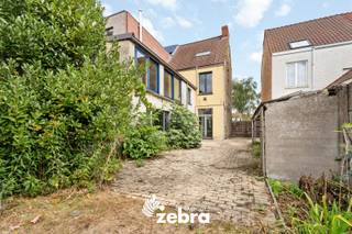 Deze halfopen bebouwing is niet alleen royaal in vierkante meters, maar ook in mogelijkheden. Ben jij op zoek naar een woning waar je jouw eigen verhaal kan schrijven? Dan is dit huis in Sint-Michiels misschien wel jouw volgende (ver)bouwavontuur! Dankzij de centrale ligging woon je vlak bij winkels, scholen en openbaar vervoer, wat deze plek extra aantrekkelijk maakt.<br /><br />Binnenkomen doe je via de inkomhal, die meteen leidt naar de leefruimte – een plek met veel licht en potentieel om een warme, open thuis van te maken. Vanuit de leefruimte wandel je zo de keuken in, die als centrale spil dient tussen binnen en buiten. Want: zowel de tuin als de badkamer, kelder én een praktische berging zijn vanuit de keuken toegankelijk. <br /><br />Op de eerste verdieping vind je een nachthal en drie volwaardige slaapkamers. De tweede verdieping biedt nog eens een nachthal en twee extra slaapkamers. En tot slot is er op de derde verdieping een zolder aanwezig.<br /><br />Buiten geniet je van een zuidwest-gerichte tuin met tuinhuis en uitweg – ideaal om te ontspannen na een drukke dag<br /><br />Deze woning is ideaal voor renovatiegerichte kopers of investeerders die willen inspelen op de sterke ligging en het ruime volume.<br /><br /><strong>Ook wild geworden van deze thuis? <br />Twijfel niet langer en leg vandaag nog uw bezoek vast! </strong>