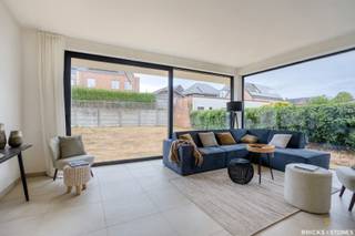 Gelegen in een rustige en groene wijk in Beerzel, vinden we deze prachtige nieuwbouwwoning met een uitstekende verbinding naar de omliggende gemeenten.<br /><br />Via de aparte inkomhal, met ingemaakte vestiaire, betreden we de woning. Achteraan, in alle rust en met zicht op de tuin, bevindt zich de ruime woon- en leefruimte. Grote raampartijen zorgen hier voor een overvloed aan natuurlijk licht en geven rechtstreeks toegang tot het terras en de zonnige tuin. De woonkamer sluit naadloos aan bij de eetruimte en de open keuken. Deze keuken is volledig uitgerust met kwalitatieve toestellen (koelkast met vriezer, combi-oven en inductiekookplaat) en beschikt over een praktisch kookeiland met spoelbak en vaatwasser.<br /><br />Aansluitend vinden we een handige berging, waar alle technieken netjes zijn weggewerkt. Bovendien is er hier voldoende plaats voor extra opbergruimte en de aansluiting voor wasmachine en droogkast.<br /><br />Op de verdieping ontdekken we drie volwaardige slaapkamers. De master bedroom (ca. 20 m²) beschikt over een en-suite badkamer met dubbele wastafel, douche én bad. De twee overige slaapkamers (ca. 18 en 19 m²) zijn eveneens ruim en delen een tweede, zeer praktische badkamer. Elke kamer heeft er een eigen wastafel, terwijl de douche gedeeld kan worden – ideaal als kinder- of gastenbadkamer.<br /><br />Deze woning werd afgewerkt met hoogwaardige materialen en oog voor detail, met technieken die garant staan voor duurzaam en energiezuinig wonen. Dankzij vloerverwarming, warmtepomp en zonnepanelen kiest u hier voor een toekomstgerichte thuis waarin comfort en kwaliteit centraal staan.<br /><br />Een woning die klasse, comfort en know-how perfect combineert.