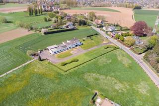 Deze veelzijdige eigendom, met 2 toegangswegen, is gelegen op een uitzonderlijk groot perceel van maar liefst 7385 vierkante meter, met eindeloos veel mogelijkheden, combineert wonen en werken op een strategische locatie met uitstekende bereikbaarheid. Het terrein is vlot toegankelijk via Kerzelare en beschikt bovendien over een bijkomende toegang langs de Vlaamse Ardennendreef.<br /><br />De site omvat een industrieel magazijn, conform Vlarem II, met een oppervlakte van ca. 600 m², uitermate geschikt voor logistieke activiteiten, opslag of atelierwerking. Daarnaast beschikt het pand over functionele burelen van ca. 180 m², ideaal ingericht voor administratieve of commerciële doeleinden.<br /><br />Boven of naast de bedrijfsruimte bevindt zich een instapklaar appartement met 4 slaapkamers en 2 inpandige garages. Met een bewoonbare oppervlakte van 359 m² en een volume van 1021 m³ biedt deze woonst tal van mogelijkheden, zowel voor eigen bewoning als combinatie met het professionele luik. Het terras, en de eigendom in zijn geheel, heeft een prachtig uitzicht over de stad Oudenaarde. <br /><br />Het appartement betrekken en gebruiken voor kantoren of operationele doeleinden is zeker een mogelijkheid. <br /><br />Verder beschikt het pand over:<br /> - 2 inpandige garages<br /> - Een groot, verzorgd perceel <br /> - Een aangelegde oprit, waar doorgaand verkeer mogelijk is<br /> - Ruime parkeermogelijkheden op eigen terrein<br /><br />Deze eigendom is uitermate geschikt voor zelfstandigen, ondernemers of investeerders die op zoek zijn naar een combinatie van wonen en werken, met voldoende ruimte en flexibiliteit.<br /><br />Ontdek deze eigendom en al zijn troeven, tijdens een bezoek ter plaatse. Contacteer Margaux op 0479 61 53 82 of op info@immomargaux.be