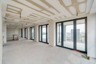 <p>Alle relevante keuringen en wettelijke attesten kan u downloaden via onze website.<br />Vragen? Neem contact op met ivory@copandi.be of via +32 15 79 05 50.<br /><br /><strong>Exclusief nieuwbouwappartement met panoramisch uitzicht – 19e verdieping, Nieuw Zuid, Antwerpen</strong></p><p>Dit exclusieve casco + nieuwbouwappartement (2024), gelegen in het prestigieuze Nieuw Zuid, combineert hedendaagse luxe met stedelijke charme. Het gebouw is ontworpen door de gerenommeerde architect Max Dudler en bevindt zich op wandelafstand van de Gedempte Zuiderdokken, het Museum voor Schone Kunsten, de Marnixplaats en tal van trendy restaurants en cafés. Hier beleeft u het beste dat Antwerpen te bieden heeft.</p><p>Op de 19e verdieping geniet dit lichtrijke appartement van een panoramisch uitzicht over de stad en de Schelde, met zicht op iconische monumenten zoals de Onze-Lieve-Vrouwekathedraal, het Centraal Station, het Havenhuis, het Museum voor Schone Kunsten en het Justitiepaleis. Grote raampartijen zorgen voor een overvloed aan natuurlijk licht, wat de ruimtes een open en luchtige sfeer geeft. Met een royale woonoppervlakte van bijna 180 m² en een ruim terras en 2 overdekte winterterrassen samen goed voor 43 m², gaat het hier om een uniek aanbod dat dag en nacht weet te imponeren.</p><p>Het appartement wordt casco verkocht en kan naar eigen smaak verder worden afgewerkt, desgewenst volgens de interieurplannen van de bekende architect Pieter Van Renterghem. Bovendien gaat het om een energiezuinig appartement met EPB-label A, volledig conform de huidige normen. De elektriciteit is conform, overal is vloerverwarming voorzien, er is een performant ventilatiesysteem D+, en in zowel de woonkamer als de masterbedroom zijn reeds de leidingen voorzien voor een aircosysteem. Dankzij deze moderne technieken geniet u van een optimaal wooncomfort met een minimale ecologische voetafdruk.</p><p>De prijs is inclusief twee kelderbergingen, beide voorzien van een stopcontact. Daarnaast zijn er twee autostaanplaatsen met elektrische laadpunten beschikbaar à 45.000 €/stuk.</p><p><strong>INDELING:</strong></p><p>De inkomhal (4 m²) geeft toegang tot een gastentoilet (1 m²). De ruime living met open keuken (68 m²) vormt het hart van het appartement en baadt in natuurlijk licht dankzij de grote raampartijen. Het appartement beschikt over twee slaapkamers (15 m² en 10 m²), een badkamer van 7 m² en een tweede badkamer van 5 m², ideaal voor extra comfort. Uniek zijn de drie terrassen van respectievelijk 25 m², 9 m² en 9 m². Samen bieden ze een ruime buitenbeleving met een van de mooiste uitzichten van Antwerpen.</p><p>Dit appartement is een absolute buitenkans voor wie op zoek is naar een combinatie van luxe, ruimte, energiezuinigheid en een onovertroffen uitzicht in het hart van Antwerpen.</p><p></p><p>✅ Luxe casco-appartement op de 19e verdieping<br />✅ Ontworpen door architect<br />✅ Panoramisch zicht op de Schelde én alle belangrijke monumenten van Antwerpen<br />✅ Twee slaapkamers en twee badkamers<br />✅ Royale leefruimte<br />✅ Drie terrassen met samen 43 m² buitenruimte</p>