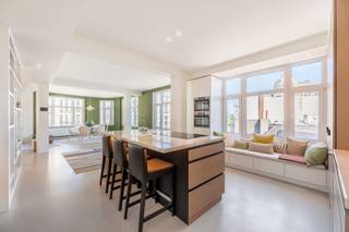 <p><strong>Luxueus gerenoveerd appartement in befaamde Meirbuilding</strong></p>
<p>Op de vierde verdieping van de Meir Building, een iconisch hoekgebouw uit 1936 van architect Joseph Baeyens, bevindt zich dit volledig gerenoveerde appartement, een uitzonderlijke woonkans in het hart van Antwerpen. Het appartement onderging een grondige renovatie met gebruik van hoogwaardige en duurzame materialen, waarbij elk detail zorgvuldig werd afgewerkt. Het resultaat is een futureproof woning die comfort en verfijning naadloos combineert en voldoet aan de strengste moderne normen.</p>
<p>Het gebouw, een prachtig voorbeeld van Art Deco-architectuur, ligt op de hoek van de Meirbrug en de Wiegstraat, op steenworp afstand van de Meir, de Groenplaats en de Wilde Zee. Een absolute toplocatie in de Antwerpse binnenstad.</p>
<p>Binnenin valt meteen de open en lichte indeling op, die zorgt voor een uitzonderlijk ruimtelijk gevoel en een panoramisch uitzicht vanuit elke hoek van het appartement. De moderne leefkeuken is volledig uitgerust en voorzien van maatkasten, een centraal kookeiland met praktische ontbijthoek en alle comfort die een hedendaagse keuken biedt. De keuken loopt vloeiend over in de woon- en eetruimte, die samen een elegante en lichte leefomgeving vormen met adembenemend uitzicht over de stad.</p>
<p>Een praktische bureauruimte, die ook afgesloten kan worden, biedt de ideale plek voor thuiswerk of kan dienen als extra logeerkamer. Aan de achterzijde bevindt zich de ruime mastersuite met ingemaakte kasten en een stijlvolle badkamer met inloopdouche.</p>
<p>Tot de extra troeven behoren een EPC B, doorgedreven isolatie, een grote aparte berging op de eerste verdieping, domotica waaronder elektrische gordijnen, de mogelijkheid tot overname van meubels en natuurlijk de unieke ligging midden in het bruisende stadscentrum. Dit appartement combineert historische allure en moderne luxe tot een uitzonderlijke woonervaring in Antwerpen.</p>
<p>Bent u ook helemaal verkocht aan dit appartement?<br />Contacteer LISTED: +32 3 283 51 51.</p>