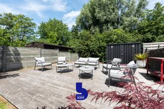 Welkom in dit bijzondere appartement waar ruimte, licht en karakter perfect samenkomen. Dankzij de royale oppervlakte voelt deze woning niet aan als een klassiek appartement maar eerder als een volwaardige woning of misschien wel jouw nieuwe thuis.<br /><br />De absolute blikvanger is zonder twijfel de prachtige, zonnige tuin. Met een ruim terras aansluitend aan de leefruimte én een tweede terras achteraan geniet je hier op elk moment van de dag van zon, rust en privacy. De zorgvuldig aangelegde beplanting creëert een feeërieke groene oase die zich perfect leent voor gezellige familiemomenten, zomerse barbecues of sfeervolle avonden met vrienden.<br /><br />Ook het gebouw zelf weet te bekoren. Opgetrokken in 2014 straalt het een tijdloze industriële architectuur uit die binnen op stijlvolle wijze wordt doorgetrokken. De zichtbare stalen balken en de elegante trap geven het appartement een unieke uitstraling en zorgen voor een warme, karaktervolle sfeer.<br /><br />De open keuken vormt het hart van de woning en werd uitgerust met alle hedendaagse comfort. Dankzij het grote schuifraam baadt deze ruimte in natuurlijk licht en loopt binnen naadloos over in het groen van de tuin. De aangename leefruimte biedt hierdoor een heerlijk gevoel van openheid en verbondenheid met buiten.<br /><br />Op het gelijkvloers bevinden zich een apart gastentoilet en een praktische was- en bergingruimte.<br /><br />Op de verdieping beschik je over twee volwaardige slaapkamers, ideaal voor een gezin, een thuiswerkplek of een hobbyruimte. Daarnaast is er een stijlvolle badkamer met ruime inloopdouche en een tweede afzonderlijk toilet, wat het dagelijkse comfort aanzienlijk verhoogt.<br /><br />Extra troeven ontbreken hier niet. Zo is er een handige fietsenberging aanwezig en beschikt de woning over een regenwaterput van maar liefst 10.000 liter. Bovendien is er geen syndicus, wat betekent dat er geen maandelijkse algemene kosten zijn.<br /><br />Dit is een woning waar het gevoel van ruimte, licht en comfort centraal staat. Een appartement met de uitstraling en het woongevoel van een huis, gecombineerd met een uitzonderlijke tuin en een unieke industriële toets.<br /><br />Een bezoek is voldoende om verliefd te worden. 