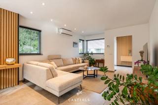 Bezoekdag op zaterdag 24 oktober 2026, uitsluitend na afspraak. <br /><br />In een rustige en kindvriendelijke woonomgeving in Wondelgem bieden wij deze hedendaagse BEN-woning aan, opgetrokken in halfopen bebouwing in 2020. De woning onderscheidt zich door een strakke architectuur, een kwalitatieve afwerking met hoogwaardige materialen en doordacht maatwerk, wat resulteert in een uitzonderlijk wooncomfort. De witte gevel, verfijnd met warme houten accenten aan de gevel en de garagepoort, geeft de woning een eigentijdse uitstraling. Achter deze gevel bevindt zich een instapklare gezinswoning waarin functionaliteit en esthetiek op harmonieuze wijze samengaan.<br /><br />Leefkeuken met karakter<br />De open leefkeuken vormt het hart van de woning. Een marmeren achterwand, een centraal eiland met dubbele spoelbak en discreet geïntegreerde designverlichting bepalen het verfijnde karakter van deze ruimte. Ze leent zich zowel voor het dagelijkse gezinsleven als voor het ontvangen van familie en vrienden.<br /><br />Doordachte indeling en hoogwaardig maatwerk<br />De woning biedt een bewoonbare oppervlakte van 158 m² en heeft een bijzonder functionele indeling. Op de verdieping bevinden zich drie slaapkamers. Eén ervan is momenteel ingericht als multifunctionele ruimte, met ingemaakte kasten, een bureau en een geïntegreerd opklapbed. Dankzij de uitgekiende inrichting en de ruime natuurlijke lichtinval kan deze kamer zowel als bureau, slaapkamer of logeerkamer worden gebruikt.<br /><br />De badkamer is eigentijds ingericht met een inloopdouche en een dubbel wastafelmeubel. De aansluitingen voor de plaatsing van een bad zijn reeds voorzien. Zowel op het gelijkvloers als op de verdieping bevindt zich een afzonderlijk toilet.<br /><br />Doorheen de woning werd gekozen voor onderhoudsvriendelijke keramische vloeren met vloerverwarming, aangevuld met airco. Accenten in marmer en eik en talrijke kamerhoge maatkasten zorgen voor een rustig en kwalitatief geheel, waarbij de beschikbare ruimte optimaal wordt benut.<br /><br />Troeven op een rij:<br />Instapklaar<br />Ingebouwde koffiecorner<br />Verfijnd maatwerk en hoogwaardige materialen<br />Vloerverwarming en airco doorheen de woning<br />Energiezuinige BEN-woning met zonnepanelen en laadpaal (thuisbatterij niet inbegrepen)<br />Geïntegreerd alarmsysteem<br /><br />Buitenruimte en garage<br />Achteraan geniet u van een aangenaam aangelegd terras en een onderhoudsvriendelijke tuin, omringd door groen. Een tuinhuis biedt bijkomende bergruimte. De inpandige garage biedt plaats aan een wagen en fietsen en staat rechtstreeks in verbinding met de woning.<br /><br />Ligging<br />De woning is gelegen in Wondelgem, ten noordwesten van Gent. De rustige, kindvriendelijke woonomgeving gaat hier samen met een vlotte bereikbaarheid van de belangrijkste invalswegen en het openbaar vervoer. Ook voor gezinnen is de ligging bijzonder gunstig. De Daltonschool (ca. 650 m) en basisschool Klimrek Van Belle (ca. 800 m) bevinden zich op korte wandel- of fietsafstand. Een apotheek, huisarts, park, speeltuin en supermarkten zoals Colruyt en Carrefour Express liggen allemaal binnen een straal van ongeveer één kilometer.<br /><br />Kortom: Een energiezuinige gezinswoning met een hoogwaardige afwerking, veel maatwerk en een uitzonderlijk praktische ligging.