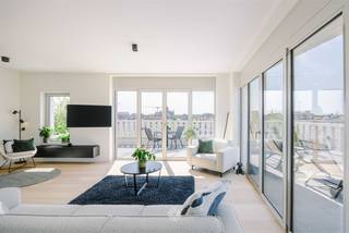 <p><span>GENT - Uniek penthouse met panoramisch terras in groene stadsontwikkeling nabij het centrum</span></p><p><span> </span></p><p><span>Op de bovenste verdieping van Residentie Artevelde (2023) bevindt zich dit ruime en energiezuinige penthouse met uitzonderlijke terrassen van ca. 113m². De combinatie van royale terrassen, grote raampartijen, hedendaagse architectuur en een groene ligging, maken dit appartement een uitzonderlijke opportuniteit met hoge mate van privacy en een unieke buitenbeleving.</span></p><p><span> </span></p><p><span>Het penthouse maakt deel uit van de Tondeliersite, een moderne stadsontwikkeling waar wonen, duurzaamheid en community centraal staan. De site bevindt zich op korte afstand van het centrum van Gent in een autoluwe woonomgeving en geniet daarnaast van een prachtige groene ruimte, voorzieningen en vlotte verbindingen.</span></p><p><span> </span></p><p><span>De belangrijkste troeven </span></p><ul><li><span>Panoramische vergezichten op het Tondelierpark en de stad</span></li><li><span>Nieuwbouwresidentie uit 2023</span></li><li><span>Top floor: vierde en bovenste verdieping</span></li><li><span>Royale terrassen van ca. 113m² met verschillende oriëntaties</span></li><li><span>Flexibele indeling: mogelijkheid om een extra kamer te creëren</span></li><li><span>Grote raampartijen, hoge plafonds en parketvloeren</span></li><li><span>Voorzien van moderne en energiezuinige technieken (BEN): airconditioning op warmtepomp, zonnescreens en zonnepanelen</span></li><li><span>Lage energiekosten: vloerverwarming via warmtenet</span></li><li><span>Luxueuze inbouwkeuken met massieve natuursteen en Miele-toestellen</span></li><li><span>Ondergrondse staanplaats en individuele laadpaal</span></li><li><span>Gemeenschappelijke fietsenberging met drie gereserveerde plaatsen</span></li><li><span>Gemeenschappelijke leefruimte met keuken en sanitair voor de bewoners van het gebouw, gelegen op het gelijkvloers</span></li></ul><p><span> </span></p><p><span>De indeling</span></p><p><span>Het penthouse is gelegen op de vierde en bovenste verdieping en is bereikbaar via de lift. De inkomhal beschikt over een apart gastentoilet en de mogelijkheid tot het plaatsen van een vestiairekast.</span></p><p><span> </span></p><p><span>Via een stalen deur bereikt u de ruime en lichtrijke leefruimte. De grote raampartijen en hoge plafonds zorgen voor een aangenaam ruimtegevoel. Vanuit de leefruimte is er rechtstreekse toegang tot het hoofdterras van ca. 85m², dat een prachtig zicht biedt over het park en de Gentse skyline. De open keuken is uitgerust met kwalitatieve toestellen van Miele. Aansluitend bevindt zich een praktische berging met aansluiting voor wasmachine en droogkast. Het bijkomende terras van ca. 26m² is toegankelijk via de keuken.</span></p><p><span> </span></p><p><span>Via de nachthal komen we aan in de eerste slaapkamer die beschikt over bijkomende kastruimte en een eigen badkamer met douche en lavabomeubel. De tweede slaapkamer geniet van een prachtige lichtinval en beschikt daarnaast over een aparte tweede badkamer en toegang tot beide terrassen.</span></p><p><span> </span></p><p><span>De huidige indeling biedt bovendien de mogelijkheid om een derde kamer te creëren. Deze kan worden ingericht als bureauruimte of als extra slaap- of logeerkamer.</span></p><p><span>Bij het penthouse horen drie exclusief gereserveerde plaatsen in de gemeenschappelijke fietsenberging. Daarnaast is er een ondergrondse autostaanplaats met laadpaal beschikbaar.</span></p><p><span> </span></p><p><span> </span></p><p><span>Over de Tondeliersite</span></p><p><span>De Tondeliersite vormt een nieuwe en duurzame stadswijk nabij het centrum van Gent. De ontwikkeling combineert woningen en appartementen met groene publieke ruimte en gemeenschappelijke voorzieningen. De gemeenschappelijke leefruimte in het gebouw versterkt het community-gerichte karakter van de site en biedt bewoners bijkomende ruimte voor ontmoeting en gedeeld gebruik.</span></p><p><span> </span></p><p><span>Belangrijk</span></p><p><span>Richtprijs penthouse: 898.000 EUR</span></p><p><span>Richtprijs staanplaats: 50.000 EUR</span></p><p><span>EPB Label A: 41 kWh/m² jaar (E21)</span></p><p><span> </span></p><p><span>Benieuwd? Contacteer Axel Lenaerts makelaars voor meer info of een bezoek via <span>Laurens@axellenaerts.be</span></span><span> of 09 245 24 24</span></p><p><span> </span></p>