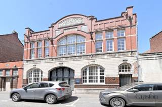 Unieke loft in voormalige elektriciteitscentrale met terras en beroepsmogelijkheden in centrum Lokeren<br /><br />Deze unieke loft van ca. 110 m² bewoonbare oppervlakte met een gezellig en lichtrijk terras van 14 m² bevindt zich in een karaktervolle voormalige elektriciteitscentrale, die recent werd gerenoveerd tot een bijzonder woonproject met slechts twee wooneenheden. De authentieke industriële uitstraling werd hierbij behouden en gecombineerd met hedendaags comfort en energiezuinig wonen.<br /><br />De loft beschikt momenteel over één ruime slaapkamer en een aparte bureauruimte, met de mogelijkheid om een tweede slaapkamer te creëren. Dankzij de aparte ingang biedt deze eigendom bovendien interessante mogelijkheden voor een vrij beroep, praktijkruimte of kantoor aan huis.<br /><br />De ruime leefruimte geniet van veel natuurlijke lichtinval en straalt dankzij de industriële architectuur een uniek loftgevoel uit. De kwaliteitsvolle keuken met inbouwtoestellen en ingemaakte kasten, vloerverwarming, ventilatie en een geluidswerend plafond zorgen voor een aangename woonbeleving. Daarnaast beschikt de woning over een praktische kruipzolder, ideaal als extra bergruimte.<br /><br />Ook op energetisch vlak scoort deze loft uitstekend met een EPC-label B en een conforme elektrische installatie.<br /><br />Parkeren vormt geen enkel probleem dankzij de vele openbare parkeerplaatsen voor de deur en in de directe omgeving. Bovendien bestaat de mogelijkheid om een overdekte staanplaats vlak naast het gebouw te huren, waarbij het huidige huurcontract kan worden overgenomen.<br /><br />Een uitzonderlijke eigendom voor wie op zoek is naar een ruime, energiezuinige loft met karakter, een unieke industriële uitstraling en tal van mogelijkheden op een centrale ligging in Lokeren.<br /><br />Praktische informatie<br />EPC: B – 184 kWh/(m² jaar)<br />Unieke EPC-code: 20220204-0002538711-RES-1<br />Elektrische installatie: conform<br />Stedenbouwkundige inlichtingen: in aanvraag<br />Bestuursmaatregelen in het maatregelenregister: geen maatregelen