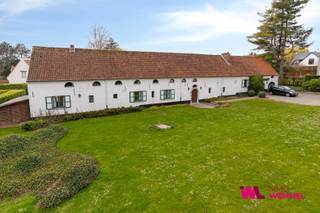 In het uiterst gegeerde en residentiële Domein van Bouchout, op de grens van Wemmel en Meise, bevindt zich deze zeldzame en authentieke hoeve oorspronkelijk van veel vroegere datum (jaren 1830?) en verbouwd in 1966. Als één van de enige hoeves binnen het domein vormt deze eigendom een absolute buitenkans voor wie op zoek is naar een woning met karakter, ruimte en uitzonderlijk potentieel.<br />Gelegen op een prachtig perceel van ca. 27 are, met een zonnig zuidwest georiënteerde tuin en zwembad, biedt deze eigendom een unieke combinatie van rust, privacy en een prestigieuze omgeving.<br />Bij het betreden van de woning komt u in een ruime inkomhal met vestiaire en gastentoilet. De lichtrijke leefruimte met open haard straalt authenticiteit en warmte uit en geeft toegang tot een charmante wijnkelder. Enkele treden hoger bevindt zich een gezellige “cosy room”, eveneens voorzien van open haard, die uitgeeft op een eerste slaapgedeelte met twee slaapkamers en een badkamer.<br />De woning onderscheidt zich door haar speelse indeling en royale volumes. Aan de andere zijde van de inkom vindt u de eetplaats, keuken en ontbijtruimte, allen met een prachtig zicht op het terras, de tuin en het zwembad. Aansluitend bevindt zich een bijkeuken met doucheruimte en diverse polyvalente ruimtes, ideaal als opslag, pantry of voormalige conciërgerie.<br />Het tweede slaapgedeelte, bereikbaar via zowel de inkomhal als de zijruimte, omvat meerdere slaapkamers met mogelijkheid tot dressing, en een ruime badkamer aansluitend op de master bedroom. In totaal beschikt de woning over 4 volwaardige badkamers, wat een uitzonderlijk comfort en flexibiliteit biedt binnen een klassieke gezinswoning.<br />Deze hoeve is niet alleen uniek door haar architectuur en ligging, maar vooral door haar uitzonderlijk renovatiepotentieel. Mits de juiste aanpak kan hier een absolute topligging gecombineerd worden met een hedendaagse afwerking op hoog niveau, met behoud van het authentieke karakter.<br />Een bijkomende en zeldzame troef is het afzonderlijk gelegen perceel van 17a 85ca, momenteel ingericht als tennisterrein, gelegen aan de overzijde van de straat (hoek Pierre Curielaan en Mercatorlaan). Dit perceel kan optioneel aangekocht worden voor €850.000 en biedt bijkomende mogelijkheden voor ontspanning of investering.<br />Een unieke opportuniteit voor wie op zoek is naar een karaktervolle eigendom in één van de meest gegeerde residentiële buurten van de regio.
