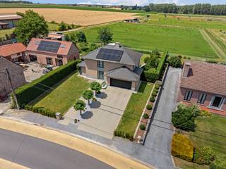 Op een rustige locatie tussen Wellen en Alken bevindt zich deze ruime en perfect onderhouden villa, gelegen op een uitzonderlijk perceel van ca. 1 hectare. Dankzij de gunstige zuidoriëntatie en de vrije ligging zonder achterburen geniet u hier van optimale privacy en een weids panorama over de omliggende velden.. Een absolute troef is het aangrenzende weiland, dat rechtstreeks bereikbaar is via een verharde weg. Dit maakt het geheel bijzonder aantrekkelijk voor dierenliefhebbers of wie op zoek is naar extra buitenruimte in een landelijke omgeving.<br /><br />Indeling: <br />De woning verwelkomt u via een ruime inkomhal met gastentoilet en handwasbakje. Op het gelijkvloers vindt u verder een gezellige zithoek, een lichtrijke eetkamer, een volledig uitgeruste keuken en een bureau. Aansluitend bevinden zich een praktische achterhal met berging/wasplaats en een inpandige dubbele garage.<br />Op de eerste verdieping zijn er vier volwaardige slaapkamers, waarvan één met dressing. De badkamer beschikt over een bad en douche. Via één van de slaapkamers is bovendien de zolder bereikbaar, wat extra opslagruimte biedt.<br /><br />Ook buiten werd veel aandacht besteed aan comfort en leefkwaliteit. De fraai aangelegde tuin beschikt over een ruim terras en een sfeervolle pergola met tuinhuis. Aan de voorzijde van de woning is er voldoende parkeergelegenheid voor bewoners en bezoekers.<br />Bovendien is de tuin volledig omheind. Het achterliggende weiland is goed toegankelijk via een aparte weg.<br /><br />Bron bewoonbare oppervlakte: EPC<br /><br />Buitengewone kenmerken:<br />- Unieke ligging met vrij uitzicht op de achterliggende velden<br />- Geen achterburen<br />- Optimale zonoriëntatie<br />- Instapklaar en uitstekend onderhouden<br />- Vier slaapkamers<br />- Inpandige dubbele garage<br />- Regenwaterput voor toiletten en buitenkranen<br />- Alarm- en branddetectiesysteem<br />- Airconditioning aanwezig<br />- Zonnepanelen (2024)<br />- Hoogrenderende Vaillant aardgasketel (2024)<br />- Laadpaal voor elektrische wagen (2026)