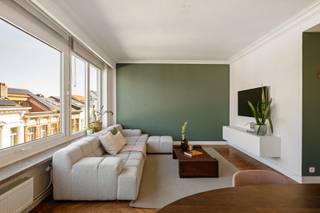 Op een gegeerde locatie in de Anselmostraat te Antwerpen bevindt zich dit instapklare appartement op de vierde verdieping van een verzorgde residentie met lift. Dankzij de grote raampartijen geniet het appartement van veel natuurlijk licht.
De inkomhal geeft toegang tot een apart gastentoilet en een praktische kastruimte met aansluiting voor de wasmachine. De volledig geïnstalleerde keuken beschikt over een inductiekookplaat, oven, microgolfoven, vaatwasser en spoelbak. Aansluitend bevindt zich een klein balkon.
De ruime, L-vormige leefruimte geniet dankzij de grote raampartijen over de volledige gevelbreedte van een prachtige lichtinval. De indeling biedt plaats aan een comfortabele zithoek en een ruime eethoek. De leefruimte is voorzien van individuele airconditioning.
De nachthal beschikt over een inbouwkast. Beide volwaardige slaapkamers zijn uitgerust met ingemaakte kasten. Ook de masterbedroom heeft individuele airconditioning.
De badkamer is ingericht met een inloopdouche, een dubbel lavabomeubel en een tweede toilet.
Dankzij de uitstekende ligging, de lichtrijke ruimtes, de praktische indeling en het moderne comfort is dit appartement een aantrekkelijke woongelegenheid in het hart van Antwerpen.