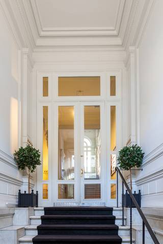 <p>Op een van de meest herkenbare hoeken van de Antwerpse Leien staat dit indrukwekkende neoclassicistische hoekpand, ontworpen door architect L. Van Opstal. Een gebouw met een verhaal, waar de grandeur van vroeger vandaag samenvalt met een sterke en toekomstgerichte vastgoedopportuniteit.<br /><br />Achter de statige gevel schuilt een karaktervol kantoorgebouw dat meteen goed aanvoelt. Via de monumentale inkomhal komt u binnen in een omgeving waar licht, ruimte en authenticiteit centraal staan. De unieke hoekligging zorgt voor grote raampartijen en een open sfeer op elke verdieping, terwijl hoge plafonds en bewaarde historische accenten het geheel een warme, inspirerende uitstraling geven. Geen anonieme kantoorruimte, maar een plek waar mensen graag werken en blijven.<br /><br />Oorspronkelijk gebouwd als stadsresidentie voor de familie Grisar, kreeg het pand doorheen de jaren een nieuwe invulling als professioneel en volledig verhuurd kantoorgebouw. Vandaag vormt het een solide investering, gedragen door stabiele huurders en de blijvende waarde van een uitzonderlijk stuk Antwerps erfgoed. De overdracht gebeurt via een aandelentransactie, wat deze opportuniteit extra interessant maakt voor investeerders die op zoek zijn naar een doordachte structuur.<br /><br />De ligging op de Leien maakt het plaatje compleet. Met de Opera, het Centraal Station en belangrijke verbindingswegen op wandelafstand geniet u hier van maximale zichtbaarheid en een vlotte bereikbaarheid, midden in het bruisende stadsleven maar met de uitstraling van een klassiek stadspaleis.</p>
<article></article>
<article>
<div>
<div>
<div>
<div>
<div>
<div>
<p>Inclusief in deze prijs zijn tevens tien parkeerplaatsen begrepen op het naastgelegen terrein aan de Louiza-Marialei.</p>
</div>
</div>
</div>
</div>
</div>
</div>
</article>
<p><span>Wenst u meer informatie of een discreet gesprek over deze investering? Neem gerust contact op met BROCOR via </span><span>info@brocor.be</span><span> of telefonisch op 03 210 90 20.</span></p>