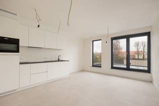 Dit recent opgeleverde appartement beschikt over een praktische indeling. Via de inkomhal met gastentoilet kom je terecht in de lichte leefruimte met open keuken. De moderne keuken is afgewerkt met een stenen werkblad en volledig uitgerust met kwalitatieve toestellen, waaronder een inductiekookplaat, dampkap, oven, vaatwasmachine en ingebouwde koelkast. Vanuit de woonkamer heb je directe toegang tot het zonnige terras. Het appartement beschikt verder over één ruime slaapkamer en een stijlvolle badkamer met lavabo en inloopdouche. Daarnaast is er een handige berging met aansluiting voor een wasmachine.  Bovendien voldoet het appartement aan alle hedendaagse energienormen en is het voorzien van vloerverwarming, een warmtepomp, zonnepanelen, ventilatiesysteem C en regenwaterrecuperatie voor de toiletten en mogelijk ook de wasmachine. Zo geniet u van een energiezuinig en comfortabel woonklimaat. Op het gelijkvloers bevindt zich bovendien een praktische gemeenschappelijke berging voor fietsen en vuilnisbakken. Daarnaast is er de mogelijkheid tot het aankopen van een carport voor 20.000 euro (excl. kosten), alle voorzieningen voor een laadpaal zijn reeds voorzien. Extra troef: het verwachte E-peil bedraagt minder dan E10, wat recht geeft op een korting van 100% op de onroerende voorheffing gedurende 5 jaar. AANKOOP AAN 6% BTW MOGELIJK! Contacteer ons voor meer info op 03 568 03 03 of lauren@vastgoed03.be