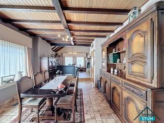 Deze ruime woning ligt in een rustige, doodlopende straat op een steenworp van diverse winkels, het openbaar vervoer en met een vlotte verbinding naar de E403. Ideaal voor wie graag rustig woont zonder in te boeten aan bereikbaarheid! Je komt de woning binnen via de inkomhal die overloopt in de nachthal. Vanuit de inkom bereik je zowel de gezellige woonkamer als de praktische dubbele garage. De lichtrijke woonkamer biedt alle ruimte voor een zit- en eetgedeelte en sluit mooi aan op de hyper-geïnstalleerde keuken. Aansluitend vind je een sfeervolle leefveranda die baadt in het licht en een prachtig zicht biedt op de fraai aangelegde tuin. Naast de keuken is er een handige wasplaats en via de nachthal bereik je de eerste slaapkamer, een gastentoilet, een bergruimte en de eerste badkamer. Deze badkamer werd in 2005 vernieuwd en beschikt over een ligbad, douche en dubbel lavabomeubel.<br />Op de eerste verdieping vind je de nachthal, vier ruime slaapkamers en een tweede badkamer met lavabo, toilet en douche. De woning is voorzien van alle extra’s die bijdragen aan comfort en duurzaamheid: een regenwaterput, een boorput, 16 zonnepanelen en airco in de veranda. De centrale verwarming op mazout houdt de woning het hele jaar door aangenaam warm.<br />Buiten geniet je van een prachtig aangelegde voortuin die doorloopt naar de achtertuin met gezellige terrasjes, wandelpaden en tuinhuizen. De lange oprit leidt je langs de woning heen tot achteraan, ideaal voor meerdere wagens. (sted. inl.: in aanvraag)