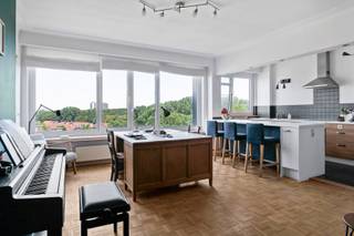 Lichtrijk appartement met terras te koop in Antwerpen

Ben je op zoek naar een energiezuinig appartement te koop in Antwerpen? Deze instapklare woonst op de zevende verdieping werd in 2015 vernieuwd en heeft een bewoonbare oppervlakte van 96 m². Met twee slaapkamers, een gunstig EPC-label B en een uitstekende staat van onderhoud is dit te koop aangeboden appartement in Antwerpen de perfecte plek om jouw nieuwe hoofdstuk te schrijven.

Bij het betreden van het appartement word je verwelkomd in de inkomhal, die toegang geeft tot het gastentoilet. Een dubbele deur met glaspanelen leidt naar de open leefruimte met een houten parketvloer en brede raampartijen die voor een warme sfeer zorgen. De woonkamer en eetkamer lopen vloeiend over in de open keuken, die is uitgerust met een eiland met barfunctie en een kastenwand. Verder bevinden zich in de woonst twee slaapkamers en de badkamer is praktisch ingericht met een ligbad met douchecombinatie en een wastafel.

Aansluitend aan de leefruimte vind je het terras van 3 m² dat zuidoostelijk georiënteerd is. Hier geniet je van een weids en vrij uitzicht over de stad en het omliggende groen.

Enkele jaren geleden werd aan de zuidoostzijde van het appartement, ter hoogte van de slaapkamers, een zonwering geplaatst. Deze zorgt tijdens warme dagen voor extra comfort en helpt de binnentemperatuur aangenaam te houden.

Dankzij het gunstige EPC-label B profiteer je in dit appartement van een uitstekende energiezuinigheid en een lager energieverbruik.

Het appartementsgebouw is voorzien van een lift die je vlot naar de zevende verdieping brengt. Daarnaast kan een privatieve garagebox op het buitenterrein optioneel aangekocht worden twv 35.000€ en is er een gemeenschappelijke, overdekte fietsenstalling aanwezig