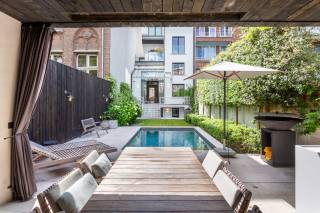 Dit uniek appartement combineert authentieke charme met hedendaags wooncomfort en een luxueuze afwerking.<br /><br />Bij het binnenkomen wordt u meteen verwelkomd in de ruime leefruimte, waar de indrukwekkende plafondhoogtes tot 4,5 meter zorgen voor een uitzonderlijk gevoel van ruimte en licht. Het elegante visgraatparket en de authentieke schouwen versterken het karaktervolle karakter van het appartement.<br /><br />De open keuken met centraal kookeiland vormt het hart van de woning en werd afgewerkt in exclusieve Calacatta Rosso natuursteen. Dankzij de doordachte indeling en hoogwaardige materialen biedt deze keuken zowel esthetiek als gebruiksgemak. Naast de eetkamer vinden we een bureel terug, eventueel te gebruiken als 3e slaapkamer.<br /><br />De slaapkamers zijn afgewerkt met duurzame kwaliteitsmaterialen en uitgerust met airconditioning voor optimaal comfort. De luxueuze badkamer straalt pure elegantie uit dankzij de combinatie van Mortex en natuursteen, met op maat vervaardigde natuurstenen wastafels en verfijnde afwerkingen. Verder nog een gastenbadkamer, ruime berging en technische ruimte.<br /><br />Buiten geniet u van een verwarmd zwembad (3 x 5 m), waarvan de verwarming gekoppeld is aan zes zonnepanelen voor een energiezuinige werking. Het overdekt terras zorgt voor een buitenervaring gedurende verschillende seizoenen.<br /><br />Troeven:<br /><br />- Oorspronkelijk gebouw uit 1940, volledig gerenoveerd in 2019-2020<br />- Plafondhoogtes tot 4,5 meter<br />- Visgraatparket en authentieke schouwen<br />- Volledig uitgeruste open keuken in Calacatta Rosso natuursteen<br />- Vloerverwarming in leefruimte, slaapkamer en badkamer<br />- Airconditioning in de slaapkamers<br />- Luxueuze badkamers met Mortex en natuursteen<br />- Ruime kelder met berging en technische ruimte<br />- Verwarmd zwembad (3 x 5 m) gekoppeld aan 6 zonnepanelen<br />- Individuele gasketel<br /><br />Een uitzonderlijke woning voor wie op zoek is naar een unieke combinatie van authenticiteit, luxe en comfort.<br /><br />Contacteer LISTED: +32 3 283 51 51.