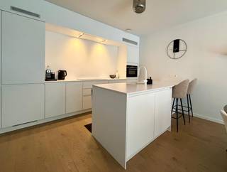 Instapklaar BEN-appartement (2021) met voortuin + terras & achteruin nabij centrum Boechout <br />Bent u op zoek naar een recent nieuwbouwappartement, maar wilt u de hoge kost van 21% btw vermijden? Dan is dit een unieke opportuniteit. Dit appartement werd opgeleverd in 2021 en verkeert in uitstekende staat.<br />Op een gunstige locatie nabij het centrum van Boechout bevindt zich dit moderne en instapklare appartement op het gelijkvloers van een mooie residentie. Dankzij de combinatie van hedendaags wooncomfort, energiezuinige technieken en een uitstekende bereikbaarheid is dit de ideale woonst voor wie zorgeloos wil genieten.<br />Bij binnenkomst wordt u verwelkomd in een lichtrijke leefruimte met open keuken en stijlvolle parketvloer. De open indeling creëert een ruimtelijk gevoel en zorgt voor een aangename woonbeleving. Vanuit de leefruimte heeft u rechtstreeks toegang tot de ruime voortuin.<br />Het appartement beschikt over twee slaapkamers, waarvan 1 slaapkamer momenteel in ingericht als dressing. De moderne badkamer is uitgerust met een ruime inloopdouche. Daarnaast zijn er een afzonderlijk gastentoilet en een praktische berging/wasruimte met plaats voor wasmachine, droogkast en technische installaties.<br />Ook op energie vlak scoort dit appartement uitstekend. Het betreft een BEN-woning (Bijna-EnergieNeutraal), uitgerust met zonnepanelen, een ventilatiesysteem en een slimme thermostaat. Dit resulteert in een comfortabele woonomgeving én lage energiekosten.<br />Verder beschikt het appartement over:<br />•Twee privatieve fietsplaatsen <br />•Gemeenschappelijke fietsenberging<br />•Private parkeerplaats (ondergrondse garage)<br />•Alle ramen zijn voorzien van vliegenramen <br />•Praktische en grote buitenberging <br /><br />Troeven op een rij:<br />✔ Opgeleverd in 2021 – quasi nieuwbouwstaat<br />✔ Aankoop onder registratierechten <br />✔ Energiezuinige woning met zonnepanelen<br />✔ Gelijkvloers<br />✔ Twee slaapkamers<br />✔ Privatieve parkeerplaats en fietsplaatsen<br />✔ Lage gemeenschappelijke kosten<br />✔ Nabij centrum, winkels, openbaar vervoer en