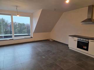 <p><span><strong>Nieuwbouwappartement met 2 slaapkamers, terras en 2 autostaanplaatsen.</strong></span><br /><br />Ontdek dit moderne duplexappartement, doordacht ingedeeld voor comfort en praktisch wonen. Bij binnenkomst betreedt u een inkomsas, die niet alleen de toegang biedt tot de tweede slaapkamer – ideaal als bureau, kinder- of gastenkamer – maar ook tot het gastentoilet. Vanuit de inkomsas loopt u door naar de open keuken, geplaatst langs één wand en volledig uitgerust met alle hedendaagse toestellen zoals inductiekookplaat, koelkast met vriesvak en vaatwasser. Ruime opbergmogelijkheden maken het geheel volledig functioneel.</p>
<p>De keuken gaat naadloos over in de lichtrijke leefruimte, met grote ramen die een aangenaam groen uitzicht bieden en een open, luchtige sfeer creëren. Vanuit de leefruimte heeft u toegang tot het noordwestelijk georiënteerde dakterras, perfect om te genieten van de namiddag- en avondzon.</p>
<p>Via de interne trap bereikt u de eerste verdieping, waar de ruime hoofdslaapkamer wacht, samen met de badkamer voorzien van modern badkamermeubel met enkele wastafel en een aparte douchecabine.</p>
<p>Praktisch ingedeeld, is de warmtepomp slim geplaatst onder de trap, waardoor de bergruimte groot en praktisch blijft, en tevens voorzien is van de aansluiting voor wasmachine en droogkast.</p>
<p>Het appartement beschikt bovendien over twee autostaanplaatsen: één vooraan op de kiezel en één veilig binnenin de residentie. De autostaanplaatsen beschikken tevens over de mogelijkheden tot het opladen van elektrische of hybride voertuigen.</p>
<span><strong>Huurprijs</strong></span>: €1150,00 per maand.<br /><br /><span><strong>Beschikbaarheid</strong></span>: bij oplevering (medio maart 2026).<br /><br /><span><strong>EPB in opmaak.</strong></span>