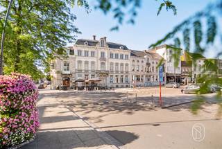UNIEKE RETAILRUIMTE MET ENORM POTENTIEEL IN HISTORISCH RONSEDit indrukwekkende pand is gelegen op de meest prestigieuze locatie van Ronse, direct aan het charmante centrale plein van de stad. Met een totale bruikbare oppervlakte van 1000 m² en een grondoppervlakte van 398 m², biedt dit monument een uitzonderlijke kans voor ondernemers met visie.ARCHITECTURAAL ERFGOEDHet gebouw is een prachtig voorbeeld van 19de-eeuwse grandeur, met een voorkant die getuigt van Haussmannische elegantie. De gevel met zijn imposante steen- en ornamenten, decoratieve balustrades en gedetailleerde architraven straalt prestige uit. Het pand heeft bewaard kunnen blijven als een van de zeldzame originele structuren op het plein.RUIMTELIJKE MOGELIJKHEDENMet tien kamers verdeeld over verschillende verdiepingen, biedt dit pand flexibiliteit voor diverse bedrijfsmodellen. De begane grond is ideaal voor retailactiviteiten met rechtstreekse toegang vanaf het drukke plein. Verdiepingen bieden ruimte voor kantoren, opslagfaciliteiten of toekomstige uitbreidingen. De royale afmetingen van individuele vertrekken permetteren creatieve interieurontwerp.OPVALLENDE KENMERKENHet interieur toont sporen van voormalige grandeur met originele stucwerk, decoratieve plafonds met gouden ornamenten en indrukwekkende schouwmantels. De lange gangen en symmetrische indeling spreken van klassieke architectuur. Bakstenen muren en houten balkenstructuren geven authenticiteit. Grote ramen bieden natuurlijk licht en zicht op het levendige plein.STRATEGISCHE LIGGINGDirect aan het centrale plein van Ronse, een hoogtepunt van openbaar verkeer en voetgangersverkeer. Omgeven door cafés, winkels en cultuurhistorische monumenten. De positie garandeert maximale zichtbaarheid en bereikbaarheid.POTENTIEEL VOOR HERONTWIKKELINGDit pand vereist renovatie, wat tegelijkertijd authentieke elementen kan behouden. Ideaal voor projectontwikkelaars, hoteliers, kantoorgebruikers of gemengde culturele ondernemingen die het historische karakter willen respecteren en moderniseren.📩 Meer info of een bezoek op afspraak via Immo Beguin: info@immobeguin.be