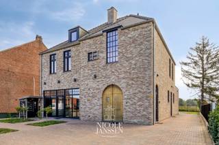 Dit veelzijdige pand combineert een zeer mooie handelsruimte op het gelijkvloers met een volwaardige ruime woning op de verdieping. Een interessante combinatie voor wie wonen en werken op één locatie wil samenbrengen. De degelijke en kwalitatieve materialen en stijlvolle inrichting maken dit pand uniek in zijn soort. De grote kelder met inrit langs achteren biedt nog extra bergruimte. <br /><br />=> Ligging<br />Dit nieuwe pand is vlot bereikbaar en geniet van een strategische locatie voor uiteenlopende handels- of professionele activiteiten. <br />Op eigen terrein is er meer dan voldoende parkeergelegenheid en de uitstekende zichtlocatie vlakbij Maasmechelen en Dilsen is bijzonder interessant. <br /><br />=> Gelijkvloers - handel<br />- Zeer mooie verbruiksruimte, ideaal voor afhaaldiensten of winkel in detailhandel<br />- Veel lichtinval in deze verzorgde winkelruimte<br />- De bruikbare handelsoppervlakte van maar liefst 175m² maken dat dit pand geschikt is voor diverse doeleinden<br />- Zo zijn er diverse luchtige werkruimtes<br />- Momenteel ingericht met een afwaskeuken, magazijn, toilet, ...<br />- Aan de voorzijde van het pand is er nog een aparte kantoorruimte, afzonderlijk te bereiken maar ook in verbinding met de achterliggende ruimtes<br />- Voldoende bergruimtes/archief<br /><br />=> Verdieping - woning<br />- Via de mooie natuurstenen trap komt men in de bovengelegen ruime woning<br />- Veel licht typeert deze ruime woonkamer<br />- L-vormige leefruimte met open keuken, voorzien van alle nodige comfort<br />- Gastentoilet met fonteintje in de hal<br />- Wasplaats/berging<br />- Ouderlijke slaapkamer met airco en rechtstreekse verbinding naar ruimte voor dressing<br />- Tweede slaapkamer met ruimte voor dressing<br />- Stijlvolle badkamer met grote inloopdouche, toilet en waskom op mooi badkamermeubel<br />- Zeer ruim terras aan de achterzijde met een zeer mooi vergezicht over de achterliggende weilanden<br /><br />=> Zolder<br />- Grote propere en geïsoleerde zolder, eventueel verder in te richten of af te werken<br /><br />=> Kelder<br />- Gegoten praktische kelder/garage van 42m², bereikbaar via een automatische sectionaalpoort<br /><br />=> Tuin<br />- Er bevindt zich nog een apart stukje tuin dat fijn privé te gebruiken is<br /><br />=> Indeling<br />-- Gelijkvloers - handelspand: winkelruimte/verbruiksruimte, bureel/ontvangstruimte met eigen ingang, toilet, grote werkplaats/atelier, twee bergruimtes en afwasruimte/berging;<br />-- Verdieping - woning: overloop, gastentoilet, L-vormige woonkamer met open keuken, wasplaats, badkamer, ouderlijke slaapkamer met ruimte voor dressing, tweede slaapkamer met ruimte voor dressing, dressings zijn gescheiden door een geïsoleerde gyprocwand, waardoor het eenvoudig is om hiervan een extra slaapkamer van te maken en ruim terras;<br />-- Zolder: grote open ruimte (verder af te werken en in te richten);<br />-- Kelder: kelder/garage van 42m²