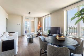 <p>Het oudste havengebied van Antwerpen, ’t Eilandje, heeft doorheen het ganse jaar zowel een vakantie als thuisgevoel. Door water omgeven en toch op 5 minuten in het centrum van ’t Stad. Wat wil je nog meer? <br /><br />Op de 14de verdieping van residentie “Westkaai 71” bevindt zich dit recent appartement van ca. 82 m², waar sereniteit en comfort harmonieus samenkomen. Dankzij de doordachte indeling en de grote raampartijen geniet het appartement van een aangename lichtinval en een ruimtelijk gevoel. Doorheen het volledige appartement werd gekozen voor een hoogwaardige parketvloer, wat zorgt voor een warme en stijlvolle uitstraling.</p>
<p>Wanneer we in de leefruimte terechtkomen zal u omvergeblazen worden van de magnifieke zichten over de Scheldebocht en de stad Antwerpen. Unieke zichten over unieke locaties, vanop het terras welke toegankelijk is vanuit de leefruimte.<br /><br />De op maat gemaakte keuken is geïnstalleerd met kwalitatieve toestellen en heeft een fijn contact met de leefruimte. Hiernaast vinden we een handige berging terug welke voorzien is van aansluitingen voor een wasmachine en droogmachine.<br /><br />Twee volwaardige slaapkamers delen een moderne badkamer voorzien van een douche in bad en een dubbele wastafel met opbergkasten.<br /><br />Een praktische kelderberging is inbegrepen in de prijs en biedt extra opbergruimte. Daarnaast bestaat de mogelijkheid om drie ondergrondse parkeerplaatsen aan te kopen aan € 37.300/stuk.</p>
<p>Je eigen uitkijkpost over de stad Antwerpen en de Schelde?<br />Kom deze samen met ons ontdekken, contacteer LISTED: +32 3 283 51 51.</p>