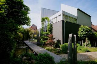 <p><strong>ARCHITECTENWONING MET MULTIFUNCTIONELE RUIMTE TE KOOP – VELTWIJCKPARK EKEREN</strong><br />Zoekt u een unieke woning waar u wonen en werken perfect kunt combineren, met extra ruimte voor uw gezin, een atelier of hobby? Wilt u centraal wonen met de natuur binnen handbereik en heeft u een hart voor moderne architectuur? Dan is deze eigendom precies wat u zoekt.</p>
<p><strong>LOCATIE & OMGEVING </strong><br /><strong>Immo Point VANDAELE</strong> stelt met trots deze architecturale parel voor. U woont hier uiterst centraal, op 450 m van het levendige centrum, 700 m van de Antwerp International School en diverse scholen binnen 1 km. Het treinstation ligt op 850 m met rechtstreekse verbindingen naar Antwerpen en Brussel, en via nabijgelegen fietsostrades staat u op 8,6 km op de Grote Markt van Antwerpen.</p>
<p>Daarnaast woont u in een groene oase: steek simpelweg de straat over voor een wandeling of hardloopsessie rond Kasteel Hof van Veltwijck, in het Veltwijckpark en in natuurgebied De Oude Landen.</p>
<p><strong>ARCHITECTUUR & TECHNIEK </strong><br />Gebouwd naar een sprekend ontwerp van architect Lou Jansen. De doordachte architectuur combineert functionaliteit met een overvloed aan natuurlijk licht.</p>
<p><strong>INDELING VAN DE WONING </strong><br /><strong>Gelijkvloers </strong><br />(Wonen & werken, atelier of hobby) Een multifunctionele ruimte van ca. 70 m² met afzonderlijke inkom en badkamer, ideaal voor een vrij beroep, praktijk of atelier. Daarnaast is er een apart bureel met rustgevend zicht op de tuin.</p>
<p><strong>Eerste verdieping </strong><br />De inkomhal is toegankelijk via een karakteristieke buitentrap. De royale, lichtrijke leefruimte (ca. 60 m²) beschikt over een gashaard en een speel- of leeshoek. De grote leefkeuken (ca. 25 m²) biedt directe toegang tot het terras. Verder vindt u hier een praktische waskamer en toilet.</p>
<p><strong>Tweede verdieping </strong><br />De nachthal heeft een apart nachttoilet en geeft toegang tot 3 volwaardige slaapkamers (elk ca. 14 m²) en een comfortabele, ruime badkamer.</p>
<p><strong>Ondergronds</strong> <br />Er is een ruime kelder én een aparte archiefruimte.</p>
<p><strong>PERCEEL & TUIN </strong><br />De ligging op een hoekperceel zorgt voor een maximaal gevoel van licht en ruimte. De volwassen, prachtig aangelegde tuin met idyllische vijverpartij creëert een heerlijk 'cocoon-effect'.</p>
<p><strong>KORTOM</strong> <br />Een lichtrijke architectenwoning met een zee aan ruimte op een toplocatie tegenover het Veltwijckpark, vlak bij alle voorzieningen en met een tuin om volledig tot rust te komen.</p>
<p><strong>BEWOONBARE OPPERVLAKTE</strong><br />De vermelde bewoonbare oppervlakte is gebaseerd op de bruikbare vloeroppervlakte uit het EPC.</p>
