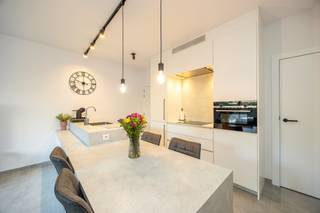 <strong>Instapklaar compact luxe-appartement (2021) met zonnetuin, terras & carport nabij centrum Brasschaat!</strong><br /><br /><strong>Plannen, indeling layout met afmetingen zie VIRTUAL TOUR ( KLIK )</strong><br /><br />Bent u op zoek naar het comfort van een villa, maar dan zonder het zware onderhoud? Dit hoogwaardig afgewerkte gelijkvloersappartement (bouwjaar 2021) combineert pure luxe met een uitzonderlijk energielabel (EPB E31!). Gelegen in een kleinschalig, modern gebouw van slechts 5 entiteiten geniet u hier van rust, privacy en een unieke sfeer, op wandelafstand van het bruisende centrum van Brasschaat.<br /><br /><strong>Zon, sfeer & buitenleven:</strong> de absolute blikvanger is de gezellige, west-georiënteerde privétuin (34 m²). Het aangelegde terras met ingewerkte palmboom en onderhoudsvriendelijk kunstgras ademt een instant vakantiegevoel uit, met directe toegang tot de carport. <br /><br />
<ul>
<li><strong>Indeling & Luxueuze afwerking: </strong>lichte design-leefruimte: Een zonovergoten woonkamer op een strakke, moderne keramische XL-tegel. De kamerhoge schuiframen zorgen voor een naadloze overgang naar de tuin.</li>
<li><strong>Open luxe-keuken:</strong> een modern, greeploos wit designeiland met een hoogwaardig naadloos werkblad (Corian/composiet) dat prachtig overloopt in een geïntegreerde eettafel. Volledig ingericht met topapparatuur (inductiekookplaat, vaatwasser, oven, grote koelkast en aparte diepvriezer) en stijlvolle, zwarte led-railverlichting.</li>
<li><strong>Mastersuite met hotel-vibe</strong>: Een royale, rustgevende slaapkamer met kamerbreed raam naar de tuin, die direct aansluit op de luxueuze open badkamer. Deze is voorzien van een royale inloopdouche met een strakke glazen wand en grote, zandkleurige wandtegels, een design-lavabomeubel met ingebouwde kraan en een slim weggewerkte maatkast voor wasmachine/droogkast.</li>
<li><strong>Sanitair & Techniek</strong>: Apart gastentoilet en een handige technische berging.</li>
</ul>
<strong>Technisch topcomfort:</strong><br />Het appartement is uitgerust met behaaglijke vloerverwarming over het volledige oppervlak, een individuele gascondensatieketel en een C-plus ventilatiesysteem. Dit resulteert in een extreem laag energieverbruik (E-peil: E31).<br /><br /><strong>Syndicus - lage maandelijkse lasten:</strong> slechts € 89/maand - syndicus, blokpolis/brandverzekering, bankkosten en gemeenschappelijk water & elektriciteit van de hal. <br />
<div><br /><strong>De perfecte match</strong> voor <strong>starters</strong>, <strong>singles of koppels</strong> <strong>die op zoek zijn naar een luxueuze thuis zonder renovatiezorgen. Eveneens ideaal voor wie kleiner wil gaan wonen met behoud van comfort & minder onderhoud, óf als een direct renderende, zorgeloze investering.</strong><span></span></div>
<div></div>
<div></div>