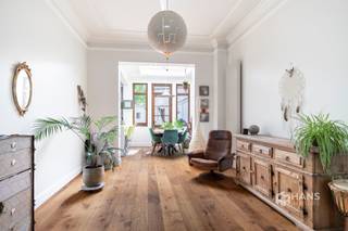 <p><span>De Neufstraat 6 - Deurne</span></p><p><span> </span></p><p><span>Characterful house (… m²) with 3 bedrooms and south facing city garden (40 m²) in Deurne.</span></p><p><span>This spacious house with authentic charm is located a stone's throw from the Rivierenhof. Thanks to the proximity of bus, streetcar and velo stations and easy access to the freeway, you enjoy excellent accessibility here. An ideal combination of tranquility, greenery and mobility.</span></p><p><span>The characterful facade immediately sets the tone. In 2011, the first floor, including the kitchen, was completely renovated and the front facade also received a refresh. In addition, the main and flat roofs as well as the rear facade were insulated, and the ground floor windows were renewed. The boiler dates from 2010. The hall, one bedroom and the bathroom still offer the possibility to modernize to your own taste — perfect to give it your personal touch.</span></p><p><span>You enter into the spacious entrance and staircase hall with separate guest toilet. To the rear is the fully equipped kitchen, which flows seamlessly into the living room, together accounting for an impressive 54 m². The skylight above the dining area provides pleasant light. Adjacent is a practical storage/laundry room (5 m²).</span></p><p><span>The south-oriented city garden of approximately 40 m² is a real asset — a cozy place to enjoy the sun.</span></p><p><span>On the second floor there are two spacious bedrooms of 16 m² and 22 m², one of which can still be finished. The upper floor houses the bathroom (11 m²) and the third bedroom (18 m²), with the possibility of converting the adjacent storage room (4 m²) into a dressing room.</span></p><p><span>Finally, the house has a dry cellar.</span></p><p><span>Are you looking for a character home with space and potential in a prime location near greenery? Do not miss this opportunity! Living area … m² ref: gross floor area. For more info or a free appraisal visit </span><span><span>www.hansimmo.be</span></span></p><p><span> </span></p>
