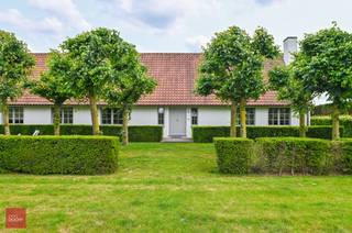Landhuis bestaande uit inkomhal, zeer ruime living met open haard, eetplaats, ingerichte keuken met ontbijthoek, gelijkvloerse slaapkamer met badkamer, ruim bureel (of hobbykamer), wasplaats en berging. 3 Slaapkamers, dressing en badkamer op verdiep. Tuin met bijgebouw (bar) en ruime garage/opslagruimte. 14 zonnepanelen aanwezig. Opp. 4.190m²<br /> 