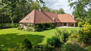 Bij het betreden van deze zeer goed onderhouden en instapklare stijlvolle villa wordt u verwelkomd in een indrukwekkende, lichtrijke inkomhal met gastentoilet en praktische vestiairekast. Via een elegante glazen deur komt u in de ruime leefruimte en eetkamer, waar grote raampartijen een fraai uitzicht bieden op de prachtig aangelegde volgroeide tuin en mooie bomen. De sfeervolle leefruimte beschikt bovendien over een open haard, stijlvolle bar, de ideale plek om in alle gezelligheid te genieten van een aperitief.<br /><br />Aansluitend bevindt zich aan de ene zijde een afzonderlijk bureau met maatwerkkasten, perfect voor thuiswerk of een professionele activiteit. Aan de andere zijde vindt u de comfortabele master suite op het gelijkvloers, bestaande uit een dressing, badkamer, boudoir en ruime slaapkamer, dit alles voorzien voor levenslang wooncomfort. Vanuit de dressing biedt een zolderluik toegang tot de ruime zolderverdieping van maar liefst 39 m² met hoge plafondhoogte die, indien gewenst, als leef- of werkruimte bij de woning betrokken kan worden.<br /><br />De volledig uitgeruste keuken geniet eveneens van een mooi zicht op de tuin en vormt het hart van de woning. Naast de keuken bevindt zich een tweede bureau en een extra polyvalente ruimte -momenteel ingericht als koele berging- die, indien gewenst, eenvoudig kan worden geïntegreerd om de keuken verder uit te breiden. Verder beschikt het gelijkvloers over een praktische wasplaats met afzonderlijke inkom, een dubbele garage met automatische poort en een aangrenzende werkplaats/atelier.<br /><br />Op de verdieping bevinden zich drie volwaardige slaapkamers. De eerste slaapkamer beschikt over een eigen sauna en douchecel. De tweede, bijzonder ruime kamer biedt tal van mogelijkheden en kan desgewenst ingericht worden als zelfstandige studio (conciërge, nanny of kangoeroewoning), aangezien de nodige aansluitingen voor een keuken en/of badkamer reeds aanwezig zijn. De derde slaapkamer is uitgerust met een eigen douchekamer en extra bergruimte.<br /><br />Ook buiten weet deze villa te imponeren. Het riante terras van 54 m² is uitgerust met tal van comfortvoorzieningen, waaronder een overdekt gedeelte, terrasverwarming, zonnetent, zonnescreens en een ingebouwde barbecue. Dankzij de gunstige zuidoostoriëntatie geniet u hier de hele dag van de zon in alle rust en privacy.<br /><br />Bovendien bestaat de mogelijkheid om de prachtig aangelegde naastgelegen tuin afzonderlijk aan te kopen. Dit perceel betreft een bouwgrond van 1.848 m² met een straatbreedte van circa 35 meter. Meer informatie en prijs op aanvraag via frederik@immovdl.be.<br /><br />Deze eigendom onderscheidt zich verder door haar uitstekende ligging in een residentiële en groene omgeving, op fietsafstand van zowel het centrum van Schilde als Sint-Antonius. Extra troeven zijn het alarmsysteem, zonnewering, de rolluiken, de vloerverwarming op het gelijkvloers, de rolstoelvriendelijke indeling met brede deuren en de grondwaterput met automatisch sproeisysteem (momenteel niet functioneel). Ook de grote private parking aan de zijkant van woning en de grote houtberging, die discreet in de tuin geplaatst is zijn absolute troeven van de woning.<br /><br />Een uitzonderlijke woning waar ruimte, comfort en een prachtige en rustige, groene omgeving harmonieus samenkomen.