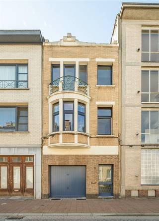 <p><span>Ruimte, groen én een garage in Deurne-Centrum? Deze instapklare woning heeft het allemaal: een lichte leefverdieping met overdekt terras, een zuidwestgerichte tuin met veel privacy, twee badkamers en een flexibel gelijkvloers dat ook perfect werkt als bureau of derde slaapkamer.</span></p><p><span>Praktisch gelijkvloers met tuincontact</span></p><p><span>Binnenkomen doe je op het gelijkvloers, waar de grote garage meteen een pak praktische ruimte biedt. Aansluitend ligt de wasberging met aansluiting voor de wasmachine, een wastafel en de condenserende gasketel van 2023. Achteraan bevindt zich een veelzijdige bureauruimte die evengoed kan dienen als derde slaapkamer, hobbyplek of rustige thuiswerkplek. Het schuifraam trekt het daglicht naar binnen en opent het zicht op de tuin. De geïsoleerde zijgevel en rolluiken met isolatie maken deze verdieping extra functioneel. De woning is bovendien volledig onderkelderd, handig voor voorraad, fietsen en alles wat je liever netjes uit het zicht bewaart.</span></p><p><span>Buiten wacht een verrassend ruime, zuidwestgerichte tuin met veel privacy. Het terras aan tuinniveau sluit mooi aan op het groen, terwijl een buitentrap de tuin verbindt met het overdekte terras op de eerste verdieping. Zo krijg je verschillende plekken om buiten te zitten, van een beschutte koffieplek tot een zonnige namiddag in de tuin.</span></p><p><span>Lichte leefverdieping met overdekt terras</span></p><p><span>Op de eerste verdieping vormen woonkamer en eetplaats één royale leefruimte. De lichte laminaatvloer houdt het geheel fris, terwijl de erker en de ramen voor- en achteraan voor een aangename lichtinval zorgen. Er is vlot plaats voor een ruim salon én een grote eettafel. Via de eetplaats stap je rechtstreeks naar het overdekte terras, een beschutte buitenkamer met zicht op het groen en een trap naar de tuin.</span></p><p><span>De aparte keuken is praktisch ingericht op een onderhoudsvriendelijke tegelvloer. Je beschikt er over een spoelbak, gasvuur, koelkast, dampkap en heel wat kastruimte. In de traphal zorgen de blokparketvloer en de karaktervolle tussendeur voor een warme, authentieke toets. Hier vind je ook een apart toilet met lavabo.</span></p><p><span>Twee slaapkamers, twee badkamers en extra comfort</span></p><p><span>De tweede verdieping is ingericht als rustige slaapzone op blokparket. De ruime slaapkamer geeft rechtstreeks toegang tot de badkamer, die is uitgerust met een toilet, een bad met douchescherm en een lavabomeubel met spiegelkast. Daarnaast is er een aparte douchekamer met douche en lavabo, bijzonder handig in de ochtendspits. De tweede slaapkamer geeft uit op een balkon en beschikt over een aparte dressing. Dankzij de flexibele bureauruimte beneden telt de woning in de praktijk twee tot drie slaapkamers.</span></p><p><span>Groen, winkels en verbindingen dichtbij</span></p><p><span>Je woont hier in Deurne-Centrum, met scholen, winkels, openbaar vervoer en belangrijke invalswegen vlakbij. Ook het Rivierenhof ligt in de buurt: 130 hectare groen met wandelpaden, vijvers, sportmogelijkheden, speelplekken en ruimte om gewoon even te ontsnappen aan de stadsdrukte. Zo combineer je een praktische stadsbasis met opvallend veel groen binnen handbereik</span></p>