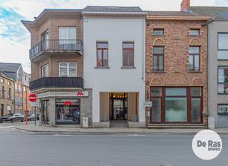 AALST - Karaktervol pand met kantoor/praktijkruimte en vernieuwd triplexappartement<br /><br />Wonen en werken combineren op een topligging in het centrum van Aalst? Dit kwalitatieve en energiezuinige pand, gelegen aan de Gentsestraat, biedt een unieke combinatie van een volwaardige kantoor- of praktijkruimte op het gelijkvloers en een ruim, vernieuwd triplexappartement op de verdiepingen.<br /><br />Op het gelijkvloers bevindt zich een volledig onafhankelijke kantoor- of praktijkruimte van ongeveer 55 m². De inrichting is praktisch en eigentijds, met onder meer vloerverwarming via warmtepomp en een kitchenette. Achteraan is er bovendien een aangename koer of terras. Een kelderruimte biedt extra mogelijkheden als archief- of bergruimte. Verder beschikt de kantoorruimte over twee afzonderlijke toiletten met daartussen een lavabo.<br /><br />De bovenliggende verdiepingen vormen samen een ruim en vernieuwd triplexappartement. Op de eerste verdieping komt u terecht in een aangename en lichtrijke leefruimte, waar de ingerichte keuken centraal werd geplaatst. Vooraan bevindt zich een ruime eetkamer, terwijl de woonkamer zich achteraan bevindt en dankzij de grote glaspartij volop geniet van natuurlijk licht en rechtstreeks toegang geeft tot het eerste terras. Aansluitend aan de keuken is er nog een praktische berging/wasplaats.<br />Op de tweede verdieping bevinden zich twee volwaardige slaapkamers. Eén van beide kamers beschikt opnieuw over een aangenaam zonneterras. De badkamer bevindt zich centraal tussen de slaapkamers en is uitgerust met zowel een bad als een douche.<br />De bovenste verdieping biedt nog een derde slaapkamer. Deze ruimte kan ook perfect worden ingericht als hobbykamer, bureau of polyvalente ruimte, afhankelijk van de noden.<br /><br />Ook op technisch vlak heeft deze woning heel wat troeven. De eigendom is goed geïsoleerd en beschikt over HR-beglazing en aluminium ramen. De verwarming gebeurt via een warmtepomp in combinatie met zonneboilers en vloerverwarming. Daarnaast is de elektrische installatie conform en zijn er afzonderlijke tellers aanwezig.<br /><br />De combinatie van een zelfstandige kantoor- of praktijkruimte met een ruime woning maakt deze eigendom bijzonder geschikt voor zelfstandigen, vrije beroepen of ondernemers die wonen en werken graag op één centrale locatie willen combineren. Tegelijk biedt de indeling interessante mogelijkheden voor wie op zoek is naar een investering met verhuurpotentieel.<br /><br />Voor meer informatie of een bezoek kunt u contact opnemen via 053/60.65.60.