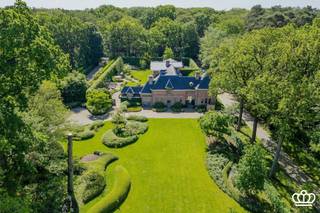 <p><span>Uitzonderlijk landgoed met luxueuze villa en stijlvolle oranjerie in het Mastenbos</span></p><p><span> </span></p><p><span>Op een steenworp van het dorpscentrum van Kapellen, gelegen in het Mastenbos, bevindt zich dit uitzonderlijke en bijzonder sfeervolle domein van meer dan 2 hectare. Het voormalige koetshuis en de authentieke oranjerie van het historische Kasteel Mastenhof werden met bijzonder veel respect voor hun karakter en architectuur gerenoveerd en vormen vandaag een uniek geheel waar historische charme, hedendaags comfort en natuur harmonieus samenkomen.</span></p><p><span> </span></p><p><span>Koetshuis / Villa</span></p><p><span>Het voormalige koetshuis werd getransformeerd tot een luxueuze villa met een uitgesproken karakter en warme uitstraling. De villa beschikt over maar liefst 6 slaapkamers en 3 badkamers. De leefruimtes omvatten een ruime zitkamer, een sfeervolle eetkamer, een bureau en een royale leefkeuken die als het kloppende hart van de woning fungeert. Vanuit de leefkeuken is er rechtstreeks toegang tot de bijzonder charmante, fraai aangelegde binnentuin met verschillende terrassen. </span></p><p><span>Authentieke architecturale elementen werden zorgvuldig behouden en gecombineerd met hedendaags wooncomfort, waardoor de villa een unieke sfeer en tijdloze uitstraling heeft. De aanwezige wellnessvoorzieningen vervolledigen het gevoel van comfort en exclusiviteit.</span></p><p><span> </span></p><p><span>Oranjerie</span></p><p><span>Als tweede volwaardige woonentiteit beschikt het domein over een prachtig gerenoveerde oranjerie. Deze karaktervolle ruimte omvat een royale leefruimte met open haard, een afzonderlijke en moderne keuken en op de verdieping een luxueuze suite met slaapkamer, dressing en ensuite badkamer.</span></p><p><span>De suite bevindt zich onder een indrukwekkend glazen dak en baadt in natuurlijk licht. Dankzij de grote raampartijen en openslaande deuren wordt een voortdurende verbinding met de tuin gecreëerd en geniet men van een weids en bijzonder fraai uitzicht over het omliggende groen. De oranjerie leent zich dan ook uitstekend als stijlvol gastenverblijf, tweede woonunit of inspirerende werk- en ontvangstruimte.</span></p><p><span> </span></p><p><span>Tuin</span></p><p><span>Ook het domein zelf is van een zeldzame kwaliteit, aangelegd in een typische Engelse stijl. De waardevolle natuur vormt een prachtig en gevarieerd geheel van bossen, weilanden en natuurlijke waterpartijen, waardoor privacy, rust en een sterk gevoel van ruimte gegarandeerd zijn.</span></p>