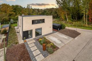 <h2><strong>Instapklare open bebouwing met EPC A+ en zicht op groen</strong><br /></h2><p>Het groen is hier nooit ver weg. Grote raampartijen brengen volop daglicht binnen en laten je vanuit de leefruimte uitkijken op de mooi aangelegde tuin en het omliggende groen. Het geeft deze open bebouwing een aangenaam gevoel van ruimte, midden in een rustige, doodlopende straat in Begijnendijk.</p><p>Binnen valt meteen de open en lichtrijke leefruimte op, met de keuken als echte blikvanger. Het royale kookeiland met Dekton-werkblad en geïntegreerde eettafel vormt een fijne plek om samen te koken, gezellig aan te schuiven of nog wat langer te blijven tafelen. De keuken sluit mooi aan op de zithoek en dankzij de grote raampartijen blijft ook de tuin altijd dichtbij. Verder is er gedacht aan praktisch comfort, met ingebouwde kasten in de inkomhal, een gastentoilet en een aparte berging.</p><p>Op de eerste verdieping bevinden zich drie volwaardige slaapkamers, waarvan de hoofdslaapkamer toegang biedt tot een aparte dressing. Een van de kamers kan uiteraard ook dienstdoen als bureau. Alle slaapkamers zijn uitgerust met airconditioning, een welkome extra tijdens warme zomerdagen. De badkamer beschikt over een mooi designmeubel met geïntegreerde lavabo, een ruime inloopdouche met regendouche en een ligbad met zicht op het groen. Ook het toilet bevindt zich hier.</p><p>Ook op energetisch vlak is deze BEN-woning helemaal mee. Met een EPC-label A+ en een energiescore van 0 kWh/(m² jaar) woon je hier bijzonder energiezuinig. De driedubbele beglazing draagt bij aan een goede isolatie en een aangenaam binnenklimaat. Een warmtepomp, zonnepanelen, een thuisbatterij van 10 kWh, vloerverwarming op het volledige gelijkvloers, een ventilatiesysteem D en een waterontharder zorgen voor hedendaags wooncomfort.</p><p>Buiten wacht een mooi aangelegde tuin met terras en gazon. Het noordwestelijk georiënteerde perceel van 509 m² grenst aan agrarisch gebied en biedt een mooi uitzicht op het omliggende groen. De groene omheining zorgt bovendien voor een aangenaam gevoel van privacy. Vooraan is er plaats voor twee wagens.</p><p>Ook de ligging combineert rust met praktisch gemak. De woning bevindt zich in een rustige, doodlopende straat, op wandelafstand van het centrum van Begijnendijk. Twee supermarkten liggen op minder dan een kilometer, de basisschool op 1,5 km en het station van Begijnendijk op 2,2 km. Ook Aarschot en de aansluiting op de E314 zijn vlot bereikbaar.</p><p>Een instapklare, energiezuinige woning waar licht, ruimte en hedendaags comfort samenkomen, met een groene en rustige ligging als extra troef.</p><figure><div></div></figure>