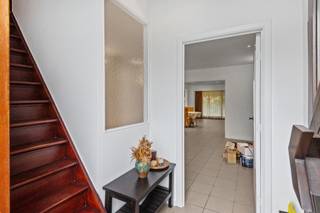 <p>Vanop straat ziet deze woning in Boom er bescheiden uit. <br />Een charmante gevel. Een voortuintje. Een huis dat netjes in de rij past.<br />Maar zoals dat wel vaker gaat met huizen: de leukste verrassingen zie je niet vanaf de stoep.<br />Dus kom gerust even binnen.</p>
<p>Op het gelijkvloers opent de woning zich helemaal naar achteren toe. De leefruimte biedt meer dan genoeg plaats voor een gezellige zithoek en een grote eettafel. De keuken sluit er open op aan.<br />Geen verzameling kleine kamertjes dus, maar één grote leefruimte waar koken, eten en ontspannen gewoon door elkaar mogen lopen.</p>
<p>Op het gelijkvloers vinden we ook de badkamer. En die doet niet aan kiezen.<br />Een ligbad en een douche, een lavabo en een toilet. Snel onder de douche tijdens de ochtendspits of uitgebreid in bad wanneer de dag erop zit: beide kampen worden hier netjes bediend.</p>
<p>Achter de grote ramen wacht nog de tuin.<br />Met ongeveer 40 m² is hij precies groot genoeg om er echt van te genieten, zonder dat tuinieren plots een tweede job wordt. Bovendien is hij zuidoost georiënteerd, waardoor je hier heerlijk van de zon kan profiteren.<br />Het terras werd overdekt. De barbecue hoeft dus niet meteen naar binnen zodra er drie druppels vallen en ook op frissere dagen zit je hier heerlijk beschut.<br />Helemaal achteraan staat nog een aparte berging/hobbyruimte.</p>
<p>Op de eerste verdieping bevinden zich drie slaapkamers.<br />Slaapkamers voor een gezin, een thuiskantoor of misschien eindelijk een kamer die volledig mag worden opgeëist door een dressing.</p>
<p>De woning telt in totaal 121 m² bew. opp. en kan hier en daar wat liefde en een frisse toets gebruiken.<br />En eigenlijk vinden we dat helemaal niet zo erg. Want de indeling zit goed. De ruimtes zijn er. En wie zin heeft om de handen uit de mouwen te steken, krijgt hier vooral de kans om van een bestaande woning opnieuw zijn eigen thuis te maken.<br />Wat je ervoor terugkrijgt?<br />Een fijne woning met drie slaapkamers, een open leefruimte, een zonnig georiënteerde tuin, een overdekt terras en verrassend veel mogelijkheden.</p>
<p>Troeven<br />- Zuidoostgerichte tuin<br />- Overdekt terras<br />- Aparte berging/hobbyruimte in de tuin<br />- 3 slaapkamers<br />- Veel potentieel om naar eigen smaak verder af te werken</p>