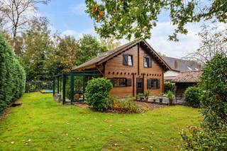 <p><strong>Charmante woning in chaletstijl met 3 slaapkamers en groene tuin nabij de Kalmthoutse Heide</strong></p>
<p>Deze charmante woning in chaletstijl is gelegen in een gegeerde, groene woonomgeving nabij de Kalmthoutse Heide. De warme houtafwerking, de gezellige leefruimtes en de tuin met veel privacy zorgen voor een bijzonder aangename sfeer. Met drie slaapkamers, een badkamer op het gelijkvloers en een multifunctionele mezzanine biedt deze woning bovendien verschillende mogelijkheden.</p>
<p><strong>Gelijkvloerse verdieping</strong></p>
<ul>
<li><strong>Inkomhal</strong> met vestiaireruimte en gastentoilet</li>
<li><strong>Badkamer</strong> met douche, lavabo en raam</li>
<li><strong>Slaapkamer op het gelijkvloers</strong>, waardoor gelijkvloers wonen mogelijk is</li>
<li><strong>Gezellige eetkamer</strong> met houtkachel en karaktervolle houtafwerking</li>
<li><strong>Aansluitende keuken</strong> met keramisch kookfornuis, dampkap en dubbele spoelbak</li>
<li><strong>Veranda</strong>, ingericht als eet- en zithoek, met grote raampartijen en twee schuiframen naar de tuin</li>
<li><strong>Praktische berging</strong> aansluitend aan de keuken, met achterdeur naar de tuin</li>
</ul>
<p><strong>Eerste verdieping</strong></p>
<ul>
<li><strong>Twee slaapkamers</strong> met een warme houten afwerking</li>
<li><strong>Mezzanine</strong>, momenteel ingericht als extra leefruimte en met mogelijkheden voor een andere invulling</li>
<li><strong>Aansluitend terrasje</strong> bij de mezzanine</li>
</ul>
<p><strong>Tuin en buitenruimte</strong></p>
<ul>
<li><strong>Groene tuin met veel privacy</strong>, omgeven door bomen en volwassen beplanting</li>
<li><strong>Overdekt terras</strong> aansluitend aan de woning</li>
<li><strong>Vrijstaande garage</strong>, momenteel in gebruik als extra bergruimte</li>
<li><strong>Bijkomende berging</strong> voor fietsen en tuinmateriaal</li>
<li><strong>Oprit met kiezelverharding</strong> en parkeermogelijkheden</li>
</ul>
<p><strong> Bijzon</strong><strong>derheden</strong></p>
<ul>
<li><strong>Karaktervolle chaletstijl</strong> met een warme houten uitstraling</li>
<li><strong>Drie slaapkamers</strong>, waarvan één op het gelijkvloers</li>
<li><strong>Badkamer op het gelijkvloers</strong></li>
<li><strong>Mezzanine</strong> met bijkomende gebruiksmogelijkheden</li>
<li><strong>Houten ramen met dubbele beglazing</strong> en buitenluiken</li>
<li><strong>Centrale verwarming</strong> met radiatoren, ook op de verdieping</li>
<li><strong>Veel privacy</strong> dankzij de groene tuin en omliggende beplanting</li>
</ul>
<p><strong>Ligging</strong></p>
<p>De woning bevindt zich op korte afstand van de prachtige Kalmthoutse Heide. De groene en gegeerde omgeving biedt een aangename combinatie van rust en bereikbaarheid. Scholen, winkels en de centra van Heide en Kalmthout bevinden zich in de nabijheid.</p>
<p><strong>Een karaktervolle woning voor wie houdt van een warme chaletstijl, een groene woonomgeving en de mogelijkheid om de woning verder naar eigen smaak in te richten.</strong></p>
Bewoonbare opp. 136 m² ref.: bruto vloeropp. EPC-certificaat<br />.0+++++++++++++++++++++++++++++