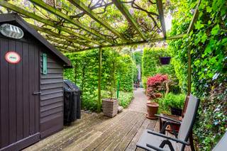 Gelegen in een rustige en aangename woonwijk te Burcht vinden we deze verzorgde en ruime bel-etagewoning terug. De woning is bovendien gelegen in een doodlopende straat met weinig verkeersdrukte, wat zorgt voor extra rust en privacy. Dankzij de groene omgeving, vlotte bereikbaarheid en praktische indeling is dit de ideale gezinswoning. Op het gelijkvloers beschikt de woning over een inpandige garage met manuele poort, een praktische wasplaats, een inkomhal met ingemaakte kasten, een apart toilet en een ruime een ruime polyvalente ruimte die perfect kan dienen als bureau, hobbyruimte, praktijkruimte of extra opslagruimte. Achteraan bevindt zich een prachtig aangelegde groene tuin met vijver en twee gezellige terrassen waar het heerlijk vertoeven is. Via de trap bereiken we de eerste verdieping. Hier vinden we een badkamer afgewerkt in graniet, voorzien van een douche, lavabomeubel en toilet. De keuken is volledig uitgerust, met uitzondering van een oven. Verder beschikt deze verdieping over een lichtrijke woonkamer op parketvloer met grote raampartijen die zorgen voor een aangename natuurlijke lichtinval. Aansluitend bevindt zich de pergola (geplaatst in 2015) met een prachtig uitzicht op de groene tuin. Via de pergola is er bovendien een rechtstreekse trap naar de tuin, wat zorgt voor een vlotte verbinding tussen binnen en buiten. Op de tweede verdieping bevinden zich drie slaapkamers, allen afgewerkt met een laminaatvloer. Twee van de drie slaapkamers beschikken bovendien over praktische ingemaakte kasten. Daarnaast is er nog een apart toilet met extra ingemaakte kasten aanwezig.