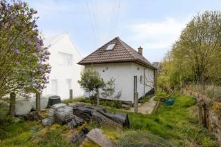 Op een unieke en uitzonderlijk rustige ligging in de Kruiskensheide 25 Lembeek bevindt zich deze instapklare woning, volledig omgeven door groen. De woning ligt in tweede bouwlijn in groengebied, weg van de straat, en is enkel bereikbaar via een smalle doorgang voor voetgangers, fietsers en brommers (niet toegankelijk met de wagen – zie plan). Dit maakt het een ideale plek voor wie op zoek is naar pure rust en privacy.

De woning werd recent grondig gerenoveerd en beschikt over een nieuw dak, nieuwe ramen en vernieuwde elektriciteit, waardoor u zonder zorgen kan intrekken.

Bij het betreden komt u in de inkomhal die uitgeeft op een open en lichtrijke leefruimte. Aansluitend bevindt zich rechts een ruime, praktische keuken met handige zijdeur.

Aan de achterzijde van de woning geniet u van een prachtig, groen uitzicht. Hier bevinden zich:

een ruime slaapkamer
een comfortabele badkamer
een apart toilet

Op de verdieping treft u een grote overloop, ideaal als bureau, speelruimte of hobbykamer. Daarnaast zijn er twee ruime en lichtrijke slaapkamers aan weerszijden.

Extra troeven:

ruime bergkelder
aangesloten op riolering
mogelijkheid tot behalen van EPC-label B na installatie van een warmtepomp (momenteel verwarmd met houtkachel)

Deze woning is een unieke opportuniteit voor wie houdt van charme, ruimte en absolute rust, midden in het groen.
Meer info: Michael@immoaccenta.be