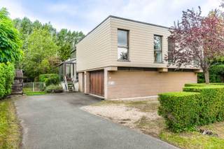 Welkom in de Krijgsbaan 227 te Zwijndrecht. <br />Je woont hier vlak bij de invalswegen richting Beveren, Antwerpen en Gent. Een woning met karakter, die je bij het opfrissen naar jouw woonwensen kan invullen.<br /><br />Via de oprit bereik je de <strong>dubbele garage</strong> en de <strong>carport</strong>.<br />De <strong>inkomhal</strong> beschikt over een <strong>gastentoilet</strong> en <strong>vestiaire</strong>.<br />Op dit niveau ligt een voormalige <strong>bureauruimte</strong>, die de laatste jaren als slaapruimte werd gebruikt. De woning biedt ook mogelijkheden voor kangoeroewonen.<br />Verder bereik je vanuit de hal het <strong>meterlokaal</strong>, een <strong>bergplaats</strong> en de <strong>garage</strong>.<br /><br />Een halve verdieping hoger ligt de <strong>leefruimte</strong>. Grote ramen brengen volop daglicht binnen, terwijl de vide en de haard het karakter van de woning bepalen.<br />De aansluitende <strong>eetplaats</strong> en <strong>veranda</strong> kijken uit op het groen. In de <strong>keuken</strong> van circa 18 m² is plaats om samen te eten en stap je rechtstreeks het terras op.<br />Op hetzelfde niveau bevinden zich de <strong>hoofdslaapkamer</strong>, een <strong>badkamer</strong> met douche, lavabo, toilet en aansluiting voor de wasmachine, en een extra <strong>bergkamer</strong>.<br /><br />Boven vind je momenteel <strong>twee</strong> <strong>slaapkamers</strong>, een <strong>bureau</strong>, de <strong>vide</strong> en een tweede <strong>badkamer</strong> met douche, toilet en lavabo. Oorspronkelijk waren hier <strong>vier slaapkamers</strong> en een <strong>speelkamer</strong>. Voor het latere gebruik als zorgwoning werden enkele tussenwanden verwijderd. Die oorspronkelijke indeling biedt aanknopingspunten om bij de renovatie opnieuw meer afzonderlijke kamers te creëren.<br /><br />De tuin loopt rondom de woning. Volwassen bomen en beplanting beperken de inkijk, terwijl het gazon en de terrassen ruimte bieden om buiten te ontspannen.<br />Onder de houten overkapping bevindt zich een jacuzzi.<br /><br /><u><strong>Technisch:</strong></u><br />- EPC: 452 kWh/m2jaar, label E<br />- Renovatieplicht<br />- G-&P-score: B&D<br />- lab, Vg, Vv, Gmo, Vkr<br /><br />Benieuwd hoe jij deze woning kan invullen? Maak een afspraak en ontdek de ruimtes en de tuin tijdens een bezoek.