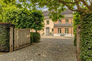 Achter een elegante houten poort, verscholen in het groen van een residentiële straat, schuilt deze charmante villa in landelijke stijl. Een...