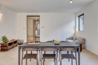 <p><strong>Vernieuwd gelijkvloers appartement in het kloppend hart van Kontich<br /></strong><strong>Welkom in Kontich: een dorp waar je de bakker nog bij naam kent, waar het leven traag genoeg bolt om ervan te genieten - terwijl je toch dicht bij al het nodige leeft. Geen wonder dat wonen hier gegeerd is! En al helemaal als je kan neerstrijken in deze karaktervolle vernieuwbouw waar élk hoekje fris en doordacht is aangepakt. Alles is hier nieuw: van gevel tot dak, van leidingen tot ramen. Hier is het thuiskomen met een hoofdletter T. Kom binnen! (doe de schoenen maar uit want 't is hier allemaal op vloerverwarming) </strong></p>
<p><strong>Welkom in de inkom</strong></p>
<p>Via de straatkant wandel je binnen in een compact gemeenschappelijk inkomsasje: netjes en overzichtelijk, met de meters van jouw unit binnen handbereik. Achter je eigen voordeur begint je verhaal écht: een lange, lichte hal die meteen de toon zet…</p>
<p><strong>Hal met mogelijkheden</strong></p>
<p>Deze gang is meer dan zomaar een doorgang: het is een ruimte op zich. Denk: plek voor wasmachine en droogkast, een elegante vestiairekast - en misschien zelfs een kunstwerk of extra opberging. Alles kan, niets moet.</p>
<p><strong>Twee kamers, eindeloos veel invullingen</strong></p>
<p>Vooraan ligt de eerste slaapkamer: perfect als logeerkamer, creatieve werkplek of bureau met zicht op het leven buiten. Achterin wacht de master: rustiger, knusser - en perfect voor nachten onder een fluffy donsdeken.</p>
<p><strong>Strak afgewerkte badkamer</strong></p>
<p>Hier kom je tot rust. Een moderne wastafel, strakke douche, zachte tegels: alles werd hier met zorg uitgekozen. Het apart toilet zorgt voor extra comfort, en de technische berging houdt alle praktische zaken mooi uit het zicht.</p>
<p><strong>Gietijzeren statement, leefruimte deluxe</strong></p>
<p>Een karaktervolle gietijzeren deur scheidt de nachthal van de leefruimte en vormt meteen een eyecatcher. De open keuken - mét keukeneiland, jawel - nodigt uit tot samen koken, lachen, tafelen. Alles is aanwezig, enkel de verlichting wacht nog op jouw persoonlijke touch.</p>
<p><strong>Zeldzaam groen</strong></p>
<p>Via grote raampartijen wandel je naar buiten, richting je eigen stukje tuin: een luxueuze zeldzaamheid in het centrum, waar je seizoensrond van kan genieten. Het terras en achterpoortje geven bovendien toegang tot de zijkant van het gebouw, handig!</p>
<p><strong>Fijn om weten</strong></p>
<p>Met een oppervlakte van 121 m², een EPC van 105 (label B) en een locatie om u tegen te zeggen, is dit een unieke kans om helemaal opnieuw te beginnen - in een pand dat volledig klaarstaat voor jouw verhaal. Tof! Bovendien kom je mogelijk in aanmerking voor een verlaagd btw-tarief van 6% - check zeker even of jij aan de voorwaarden voldoet.</p>
<p><strong>Verliefd? <u>Info@ugly.be</u> </strong></p>
<p></p>