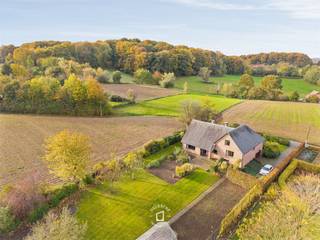 <strong>BEZOEKAANVRAGEN: enkel via mail: stephanie@immodelestre.be. </strong>Gelegen op een perceel van 23 a 24 ca, omgeven door groen en weidse zichten, grenzend aan het Neigembos, Berchembos en het Pajottenland ligt deze tijdloze villa met garage & een bewoonbare opp. van maar liefst 370 m² aan de gekende Nellekensberg. De ligging biedt de perfecte combinatie van absolute rust en privacy.<br />De ruime inkomhal met vestiaire en gastentoilet leidt naar de sfeervolle living met eetplaats afgewerkt met gezellige houthaard. Aansluitend bevindt zich de ruime keuken waar u geniet van prachtige vergezichten. Al deze lichtrijke ruimtes staan in mooi contact met de tuin en omgeving. Op de 1e verdieping zijn er 3 ruime slaapkamers en een ingerichte badkamer. De 2e verdieping biedt nog plaats voor 4 extra slaapkamers of polyvalente ruimtes of bergruimtes. Verder beschikt het domein ook over een ruime kelder, dat vandaag dienst doet als garage, berging, wasruimte, wijnkelder, voorraad, douche-toilet en stookplaats. Deze woning combineert een uitzonderlijke ligging met een zeldzaam gevoel van rust en privacy, op slechts een steenworp van alle faciliteiten, op de grens tussen Meerbeke, Gooik en Roosdaal met een vlotte verbinding naar Brussel en Gent. Kortom, een magnifieke eigendom waar u geniet van prachtige vergezichten in alle rust en privacy.<br />EPC LABEL D. CV STOOKOLIE. Beschikbaar: onmiddellijk.