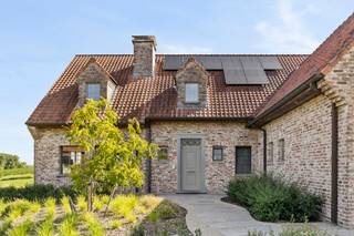 Unieke eigendom op 3.000 m² met 6 slaapkamers waarvan 2 met dressing, 2 badkamers, bureauruimtes en volledig onderkelderd (2,6 m hoog). Ingerichte keuken, vloerverwarming via warmtepomp, zonnepanelen (7.000 kWh), regenwateropvang (70.000 L met UV-filter). Dubbele garage, overdekt terras, aangelegde tuin met waterpartij, 2 paardenboxen. 2 laadpunten, B&amp;B- of kangoeroewoning mogelijk.