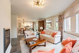 <p><span>Deze ruime villa is gelegen op een centrale locatie en met een perceel oppervlakte van 4.181m². </span></p><p><span> </span></p><h3><span>Inkom en leefruimte</span></h3><p><span>Bij het betreden van de woning komt u in een verzorgde inkomhal met gastentoilet en handenwasser.<br />De lichtrijke leefruimte vormt het hart van de woning, waar grote glaspartijen zorgen voor een aangename lichtinval en een prachtig zicht op de tuin.</span></p><p><span> </span></p><h3><span>Open keuken en praktische ruimtes</span></h3><p><span>Aansluitend bevindt zich de open keuken, volledig uitgerust met kwalitatieve toestellen, waaronder:</span></p><ul><li><span>dubbele spoelbak </span></li><li><span>combi-oven </span></li><li><span>keramische kookplaat van Miele </span></li><li><span>vaatwasser van hetzelfde merk </span></li></ul><p><span>Naast de keuken is er een praktische bergruimte met ingemaakte kasten en extra spoeltafel.</span></p><p><span> </span></p><h3><span>Veranda en verbinding met buiten</span></h3><p><span>Vanuit de leefruimte heeft u directe toegang tot de veranda, waar u het hele jaar door kan genieten van een aangename combinatie van binnen- en buitengevoel.</span></p><p><span> </span></p><h3><span>Garage en parkeergelegenheid</span></h3><p><span>De berging geeft toegang tot de garage met:</span></p><ul><li><span>automatische poort </span></li><li><span>ingemaakte kasten </span></li><li><span>aansluitingen voor wasmachine en droogkast </span></li></ul><p><span>Binnen is er plaats voor één wagen.<br />Daarnaast beschikt de woning over een carport voor twee wagens en een ruime oprit.</span></p><p><span> </span></p><h3><span>Slaapkamer en badkamer op het gelijkvloers</span></h3><p><span>Op het gelijkvloers bevindt zich een extra slaapkamer met ensuite badkamer, uitgerust met:</span></p><ul><li><span>inloopdouche </span></li><li><span>toilet </span></li><li><span>wastafelmeubel </span></li></ul><p><span>Ideaal voor gelijkvloers wonen.</span></p><p><span> </span></p><h3><span>Verdieping met meerdere slaapkamers</span></h3><p><span>Op de eerste verdieping leidt de nachthal met houten vloer naar vier volwaardige slaapkamers.</span></p><ul><li><span>Twee slaapkamers zijn afgewerkt met een novilon vloer </span></li><li><span>Eén van deze kamers biedt toegang tot een tussen- en achterkamer, perfect voor het creëren van een dressing en extra badkamer </span></li><li><span>De overige slaapkamers zijn voorzien van een warme houten vloer </span></li></ul><p><span>De badkamer op deze verdieping beschikt over:</span></p><ul><li><span>douche </span></li><li><span>toilet </span></li><li><span>wastafel </span></li></ul><p><span> </span></p><h3><span>Technische uitrusting</span></h3><p><span>De woning is technisch goed uitgerust met onder meer:</span></p><ul><li><span>alarmsysteem met meldkamer </span></li><li><span>verwarmingsketel van Buderus </span></li><li><span>waterontharder </span></li></ul><p><span>Daarnaast is er een ruime kelder aanwezig, ideaal voor stockage of het inrichten van een wijnkelder.</span></p><p><span> </span></p><h3><span>Tuin en buitenruimte</span></h3><p><span>Het buitengedeelte omvat een ruim terras met zuidoostelijke oriëntatie, waardoor u optimaal geniet van de zon.<br />Zowel de voor- als achtertuin zijn mooi aangelegd, volledig omheind en voorzien van tuinhuizen.</span></p><p><span> </span></p><h3><span>Extra troef: bijkomend perceel</span></h3><p><span>De villa wordt verkocht samen met het naastliggende perceel.<br />Dit perceel omvat twee kadastrale nummers en biedt potentieel voor het creëren van een extra bouwgrond.</span></p><p><span> </span></p><p><span>Interesse? Contacteer ons voor meer informatie of een bezoek ter plaatse.</span></p><p><span> </span></p>