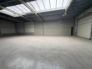 <strong>ALGEMEEN</strong><br />
<p>Deze gloednieuwe bedrijfsunit met showroom maakt deel uit van een modern bedrijvenpark en combineert hoogwaardige materialen met een vlotte bereikbaarheid. Dankzij de ligging nabij de E17 en E40 is de site centraal gesitueerd voor klanten en leveranciers.</p>
<p>De unit zelf biedt een oppervlakte van ca. 420m² en een vrije hoogte van 5 m. De basisstructuur bestaat uit een stevige staalconstructie met prefabbetonnen of gemetselde wanden, een geïsoleerd steeldeckdak met lichtdoorlatende rookluiken en een polybetonvloer die een gelijkmatige belasting tot 30 kN/m² aankan. De vlakheid van de vloer blijft binnen 5 mm op 2 m, ideaal voor uiteenlopende bedrijfsactiviteiten.</p>
<p>Toegang gebeurt via een geïsoleerde aluminium sectionaalpoort (gelijkvloers, zonder ramen) en aluminium buitenschrijnwerk met hoogrendementsglas. Natuurlijke ventilatie, nutsvoorzieningen voor gas, water en elektriciteit, en 6 privatieve parkeerplaats zijn inbegrepen. Het dak is voorbereid op de plaatsing van zonnepanelen.</p>
<p>Een toekomstgerichte KMO-ruimte die perfect inspeelt op de noden van lichte productie, opslag of ambachtelijke activiteiten.</p>
<article>
<div>
<div>
<div>
<div>
<div>
<div>
<p>Elke unit beschikt over minstens 6 eigen parkeerplaats en bezoekers kunnen gebruikmaken van extra gemeenschappelijke parkeerruimte op het terrein. De oplevering is gepland voor Q3 2025.</p>
</div>
</div>
</div>
</div>
<div>
<div></div>
</div>
</div>
</div>
</article>
<div><strong>FINANCIEEL</strong></div>
<strong><br /></strong>Verkoopprijs : €770.125 excl btw en kosten<br />(Deze prijs is inclusief 6 parkeerplaats)<br /><br />Bijkomende kosten per unit: <br />Aandeel basisakte: €950 excl.btw<br />Aansluiting nutsvoorzieningen: €7.500 excl. btw<br />Opmaak postinterventiedossier: €500 excl. btw<br />Opmetingsplan: €750 excl. btw
