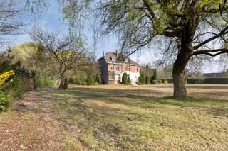 Deze karaktervolle woning is gunstig gelegen in Mol-Wezel en biedt een vlotte verbinding naar omliggende gehuchten, gemeenten, de Zuiderring en Nederland.<br /><br />Bij binnenkomst via de statige inkomhal, voorzien van een vestiaireruimte en een gastentoilet, leidt een dubbele deur naar de ruime woonkamer. Deze is opgedeeld in een zithoek en een eethoek, met grote raampartijen aan de voor- en achterzijde die zorgen voor overvloedig natuurlijk licht. De open haard voegt extra gezelligheid toe. Een tweede leefruimte aan de tuinzijde is perfect bruikbaar als extra zithoek, bureau of hobbyruimte en biedt directe toegang tot het terras. Verder bevindt zich op het gelijkvloers een ruime keuken en geeft de zij-inkom toegang tot een douchecel en een extra toilet.<br /><br />Op de eerste verdieping geeft de nachthal uit op vier slaapkamers, een badkamer, een extra toilet en een berging. Een vaste trap leidt naar de zolderverdieping, waar nog drie ruime slaapkamers, een berging en een zolderkamer aanwezig zijn.<br /><br />De woning is volledig onderkelderd, wat tal van mogelijkheden biedt voor renovatie en extra opslagruimte.<br /><br />De royale tuin kan volledig naar eigen smaak worden ingericht en biedt dankzij de ruime oppervlakte heel wat mogelijkheden. Bovendien is het perceel langs de achterzijde bereikbaar. De twee bijgebouwen kunnen dienst doen als garage of extra opslagruimte.<br /><br />Deze villa wordt vermeld in de Inventaris Onroerend Erfgoed als een woning met een verhoogde middentravee. Dit betekent echter niet dat het pand als beschermd erfgoed erkend is. Bescherming als monument of stadsgezicht vereist een specifieke procedure en officiële erkenning.<br /><br />Mits de nodige renovatiewerken kan deze unieke woning worden omgevormd tot een echte parel!<br /><br />Dit pand is onderworpen aan de renovatieverplichting van de Vlaamse overheid voor niet-residentiële gebouwen (behoudens bij sloop binnen 5 jaar na de aankoop). Consulteer voor meer informatie de website van het Vlaams Energie- en Klimaatagentschap via https://www.vlaanderen.be/een-woning-kopen/renovatieverplichting-voor-residentiele-gebouwen-vanaf-2023.<br /><br />— Stedenbouwkundige inlichtingen in aanvraag —