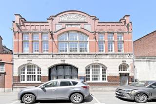 Unieke loft in voormalige elektriciteitscentrale met terras en beroepsmogelijkheden in centrum Lokeren<br /><br />Deze unieke loft van ca. 110 m² bewoonbare oppervlakte met een gezellig en lichtrijk terras van 14 m² bevindt zich in een karaktervolle voormalige elektriciteitscentrale, die recent werd gerenoveerd tot een bijzonder woonproject met slechts twee wooneenheden. De authentieke industriële uitstraling werd hierbij behouden en gecombineerd met hedendaags comfort en energiezuinig wonen.<br /><br />De loft beschikt momenteel over één ruime slaapkamer en een aparte bureauruimte, met de mogelijkheid om een tweede slaapkamer te creëren. Dankzij de aparte ingang biedt deze eigendom bovendien interessante mogelijkheden voor een vrij beroep, praktijkruimte of kantoor aan huis.<br /><br />De ruime leefruimte geniet van veel natuurlijke lichtinval en straalt dankzij de industriële architectuur een uniek loftgevoel uit. De kwaliteitsvolle keuken met inbouwtoestellen en ingemaakte kasten, vloerverwarming, ventilatie en een geluidswerend plafond zorgen voor een aangename woonbeleving. Daarnaast beschikt de woning over een praktische kruipzolder, ideaal als extra bergruimte.<br /><br />Ook op energetisch vlak scoort deze loft uitstekend met een EPC-label B en een conforme elektrische installatie.<br /><br />Parkeren vormt geen enkel probleem dankzij de vele openbare parkeerplaatsen voor de deur en in de directe omgeving. Bovendien bestaat de mogelijkheid om een overdekte staanplaats vlak naast het gebouw te huren, waarbij het huidige huurcontract kan worden overgenomen.<br /><br />Een uitzonderlijke eigendom voor wie op zoek is naar een ruime, energiezuinige loft met karakter, een unieke industriële uitstraling en tal van mogelijkheden op een centrale ligging in Lokeren.<br /><br />Praktische informatie<br />EPC: B – 184 kWh/(m² jaar)<br />Unieke EPC-code: 20220204-0002538711-RES-1<br />Elektrische installatie: conform<br />Stedenbouwkundige inlichtingen: in aanvraag<br />Bestuursmaatregelen in het maatregelenregister: geen maatregelen
