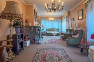 Bent u op zoek naar een charmante villa met karakter, ruimte en uitzonderlijke mogelijkheden op een topligging in Sint-Niklaas?<br />Dan is deze woning beslist iets voor u!<br /><br /><u><strong>Voor meer info kubra@ocvastgoed.be of 0465 08 41 48! </strong></u><br /><br />Deze charmante villa bevindt zich op een ruim perceel met een mooie parktuin en geniet van een uitstekende bereikbaarheid en zichtbaarheid. De combinatie van groen, privacy en een gunstige ligging maakt dit eigendom ideaal voor wie comfortabel wil wonen en eventueel wonen en werken wil combineren.<br /><br />Via de zijdelingse oprijlaan bereikt u de woning, met plaats voor meerdere wagens, een dubbele garage en een achterliggend magazijn. Zowel de voortuin als de afgesloten achtertuin zorgen voor een aangename buitenbeleving.<br /><br />Bij het betreden van de woning komt u in een ruime inkom- en traphal. Aan de voorzijde bevindt zich een bureauruimte met groot raam, ideaal als thuiswerkplek of praktijkruimte. De lichtrijke woonkamer beschikt over drie grote raampartijen en een elegante marmeren schouw met geïntegreerde houtkachel. Aansluitend vindt u de eetkamer, die via grote raam- en deurpartijen in verbinding staat met het terras en de tuin, en tevens toegang biedt tot de oprijlaan richting garage.<br /><br />De keuken sluit aan op de eetkamer en geeft toegang tot een gastentoilet en een wasplaats/technische ruimte met buitendeur.<br /><br />Op de eerste verdieping bevinden zich twee ruime slaapkamers en twee bijkomende kamers, evenals een badkamer met bad/douche, lavabo en toilet. De zolderverdieping, bereikbaar via een uitschuifbare trap, biedt extra bergruimte en potentieel.<br /><br />Deze woning vormt een mooie opportuniteit voor wie op zoek is naar een eigendom met karakter, ruimte en toekomstmogelijkheden in een groene, maar strategische omgeving.<br /><br />Bruto vloeroppervlakte (opgemeten volgens EPC) : 172 m2 hoofdgebouw + 100 m2 bijgebouw. <br /><br />Stedenbouwkundige inlichtingen: bouwvergunning, geen verkavelingsvergunning, woongebied, geen voorkooprecht, geen gerechtelijke herstelmaatregel of bestuurlijke maatregel opgelegd.<br />Geen risicozone overstromingsgevoelig gebied. P-score = B, G-score = A, wel renovatieverplichting <br />Elektriciteit niet conform <br />EPC: 813 kWh (F)